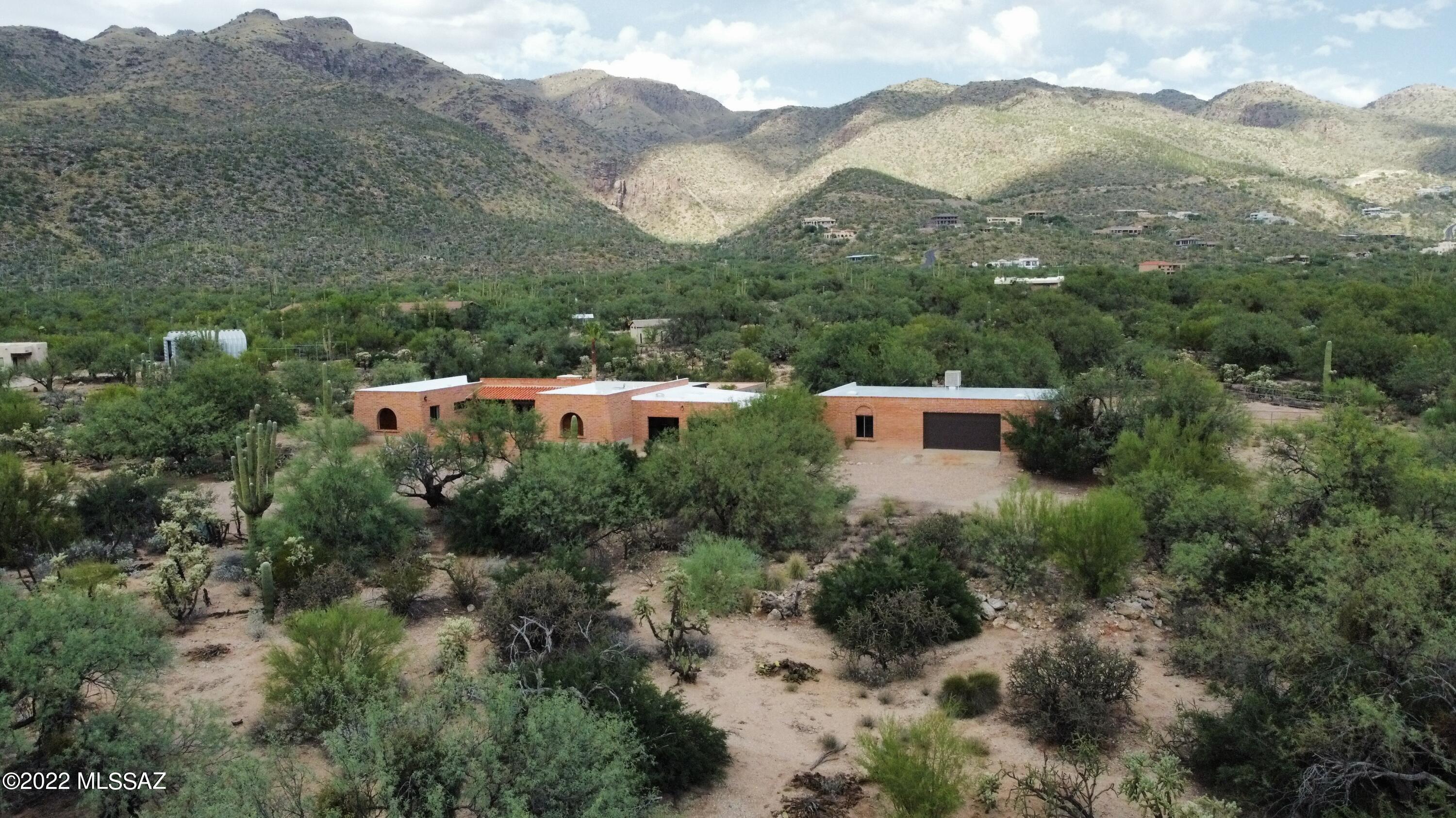 VIEWS! VIEWS! VIEWS! Dream Garage. Fabulous PRIVATE Tanque Verde Home: Burnt adobe construction off the main road, end of cul-de-sac GORGEOUS unobstructed Catalina view! This home has it all! Large Living room with wood burning fireplace and wet bar. Split bedroom floor plan. Gourmet Kitchen with custom cherry cabinets, new stainless steel appliances, granite counters, pot filler, and a lot of storage.3.56 acres, Horse Corral with slab ready for Tack room. 4 car carport and up to 6 car DREAM GARAGE with pit and air compressor, built for car enthusiast in mind! Pool, Covered Patio and walled in yard.  Star gazers delight!  Tanque Verde Schools. Just before the base of Mt Lemmon.