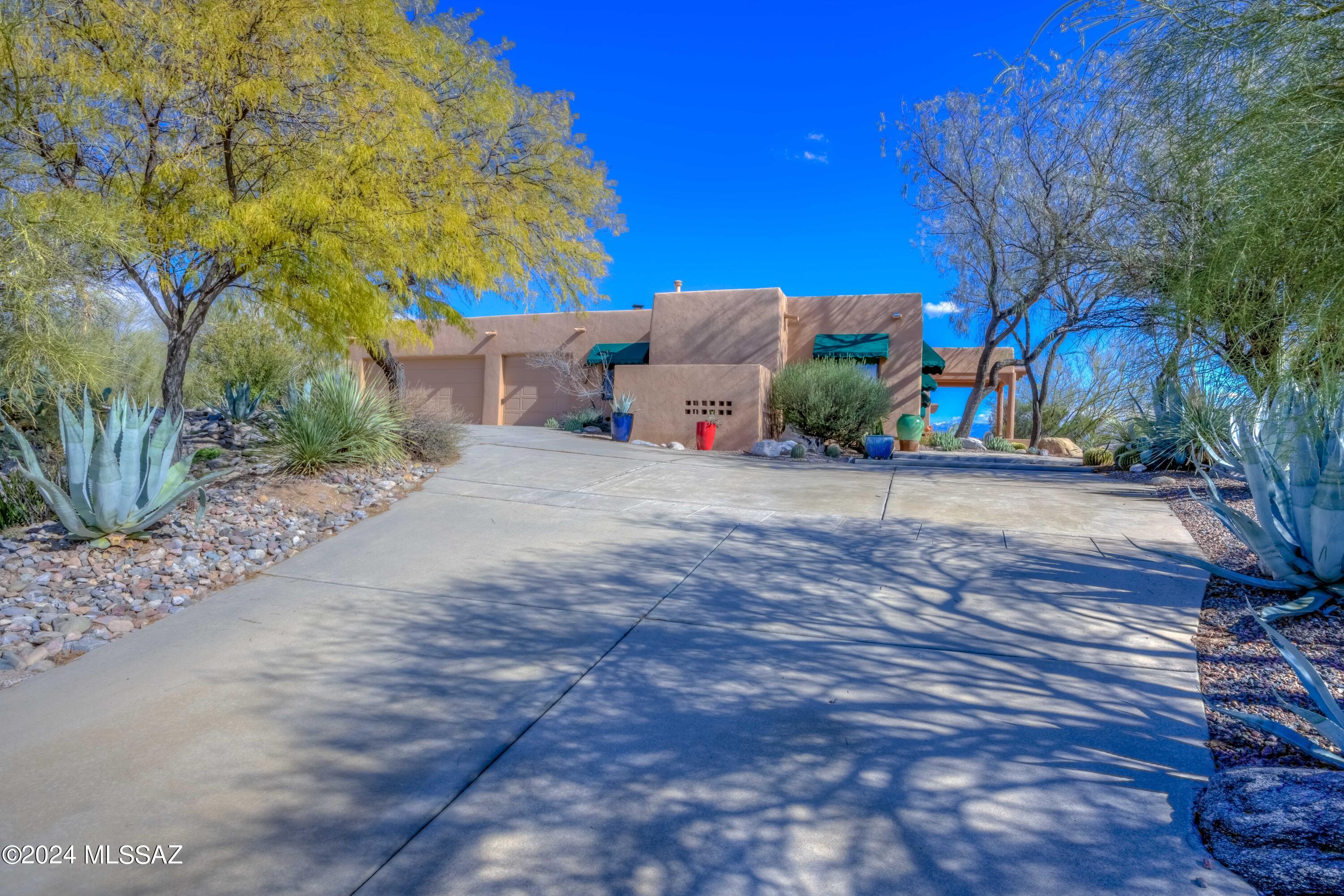 Gorgeous custom home on 1.2 acres, at the end of a cul-de-sac with panoramic views! Four bedrooms plus an office, 2.5 bathrooms, three beehive fireplaces, three car garage and plenty of storage; attached workshop room or storage room. Ample driveway space and an additional parking area for entertaining. Community pool is just around the corner! Some rooms have 13' ceilings with Viga beams. Well maintained Saltillo tile and newer carpet. Kitchen features granite countertops and walk-in pantry. No stairs inside the home. Home was designed and built by architect John Archer. Hand carved front doors. Hurry on this custom gem!