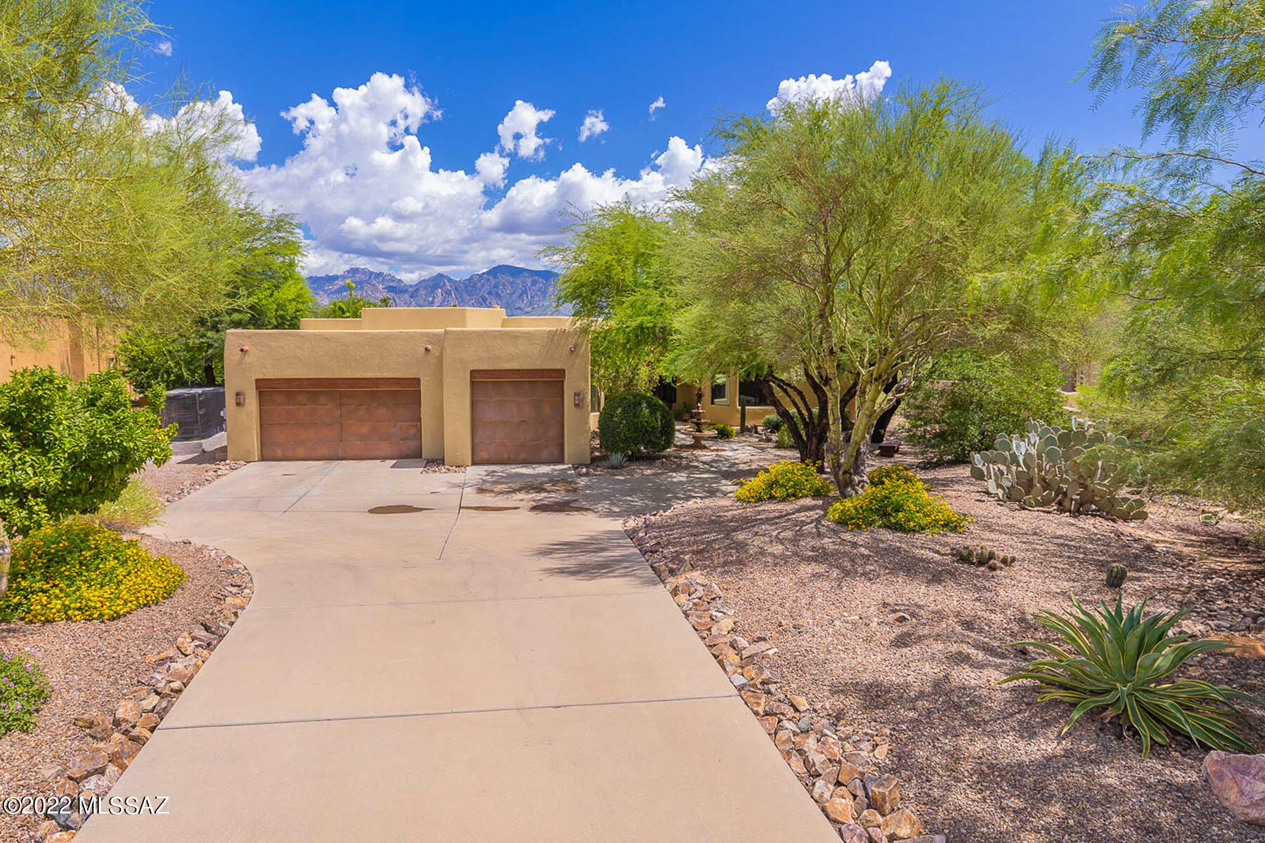 Spectacular 4BD/3.5BA (3,379 SF) estate on large cul-de-sac lot boasts a sparkling pool, owned solar and majestic Catalina views. Formal dining room overlooks front walkway w/fountain. Living room off atrium has built-in art/media wall. Open concept Great room hosts a Cantera stone fireplace, view windows and gourmet kitchen w/breakfast bar & nook, island, granite counters and stainless appliances. Private Owner's suite w/patio access adjoins den/office and hosts a luxury bath w/glass block shower & soaking tub. Amenities include guest room w/ en-suite bath, walk-in closets in all bedrooms, full hall bath, powder room. Extended 3-car garage has enclosed, air-cooled third bay. Resort-like yard boasts a covered patio, grill station, saltwater pool and colorful sunsets upon the Catalinas!