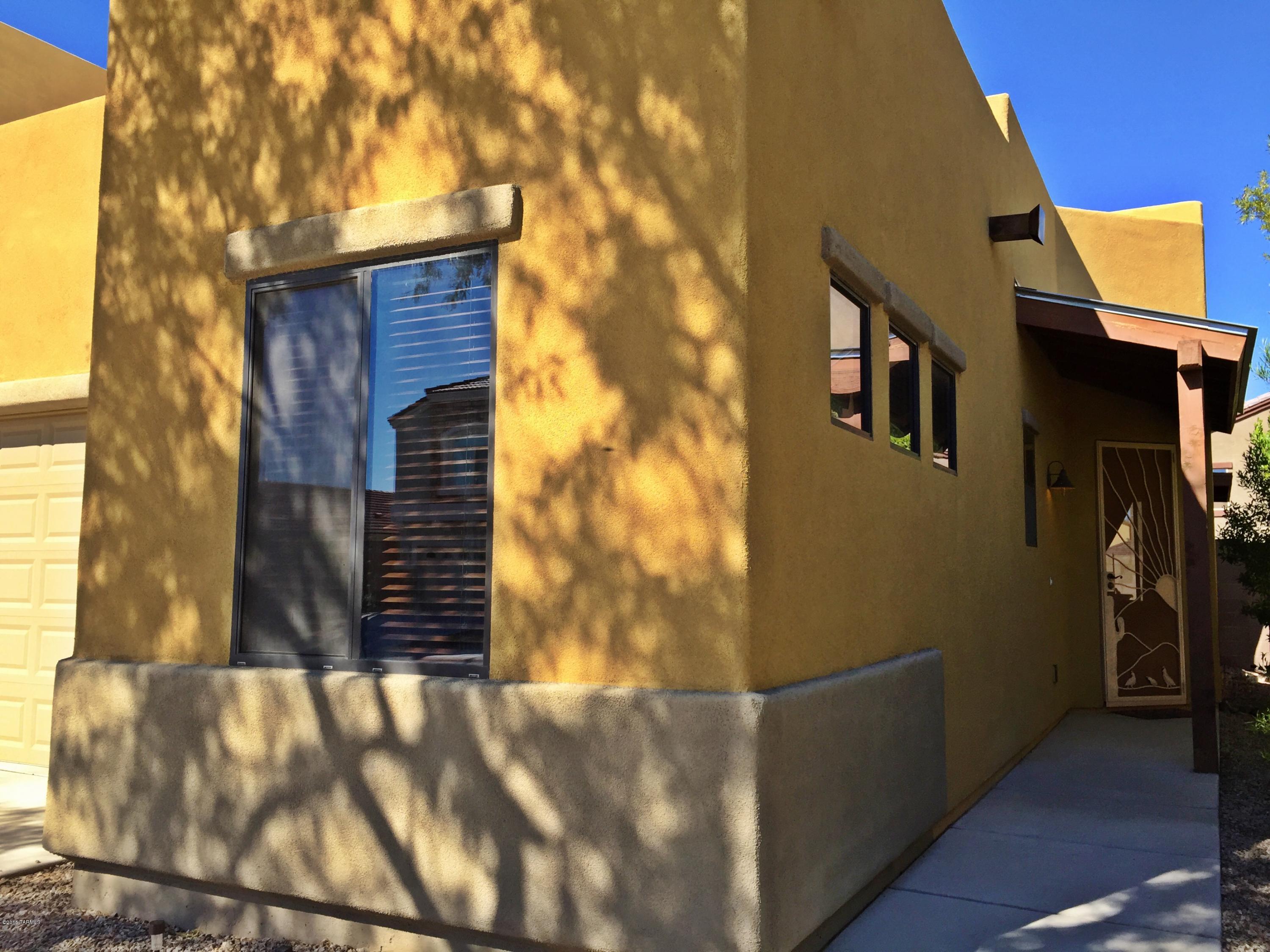 Amazing opportunity in this sought after gated golf course community! Access to I-10 is just minutes away! Beautifully designed southwestern style home has all the right touches. Feel like you're finally home when you are welcomed by the custom iron door as you head up the walk way. Gorgeous cabinetry with granite counter in the kitchen accompanied by a flat top glass stove and matching microwave and refrigerator. The great room is exactly that.... GREAT! It is large and offers room to entertain. The bedrooms are spacious as well, with the master having a large walk-in closet. The master bath offers dual vanities, tub, and shower. The back yard is super low maintenance boasting an artificial lawn and raised wall for  added privacy.