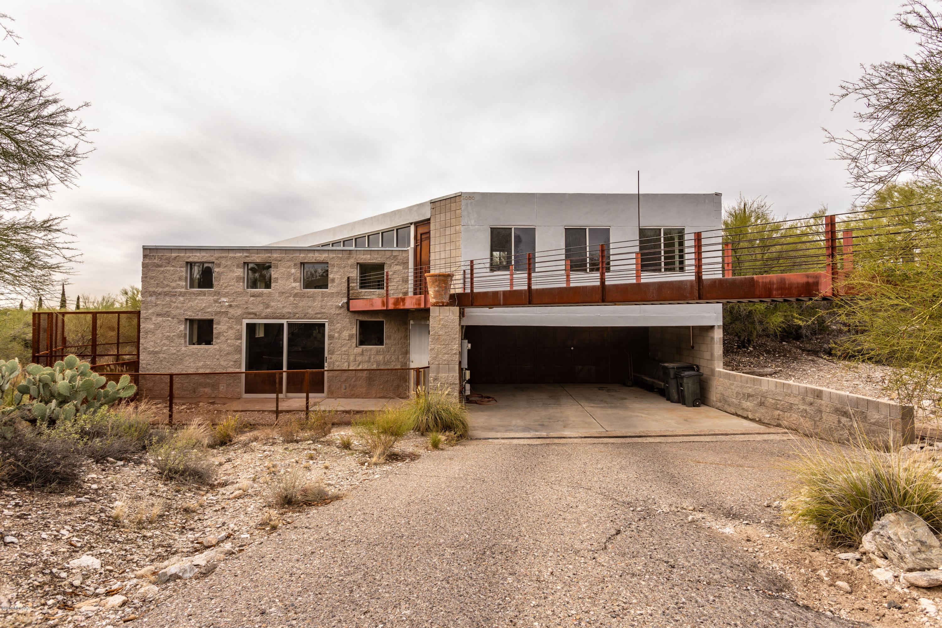 Unique industrial contemporary in the Foothills features block and steel construction. The panoramic view of the city and mountains is a sight to behold from windows that extend from floor to ceiling. This one-of-a-kind home is tucked into the hillside and boasts a large great room, spacious  loft area, and a studio with a private entrance and bath. Don't miss this rare opportunity to add your final touches and customize your dream home.