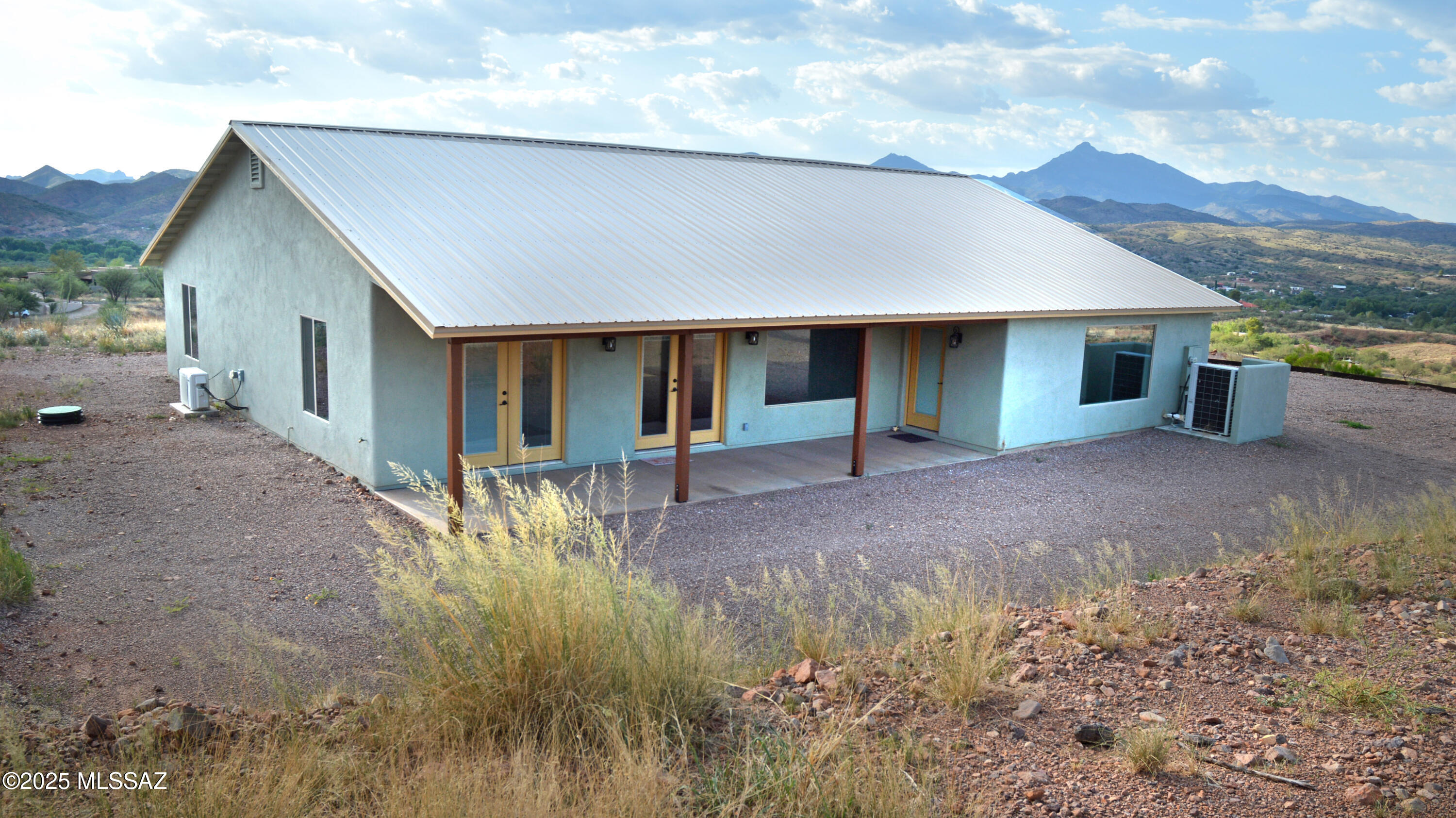 This hilltop home in the northern foothills of Red Mountain sits just above historic Patagonia. Its dramatic, unencumbered 360 views include Mt. Wrightson & the Santa Rita's; the Canelo Hills; Red Mountain & the Patagonia's & Patagonia village just below... which is an easy & convenient walk down! Situated in a very handsome gated community & sitting far back from the road, this is a truly spectacular setting. Gently regional in style & built in 2023, its 1,805sf include a 3Be split-plan with 2Ba & a spacious Great Room at center, plus an attached 2car Garage. Beautifully executed & barely lived in, you'll find the overall home & each room quite gracious. Bright & sunny, the home's many windows guarantee an exceptionally upbeat experience. All that's missing are a few landscaping touches!