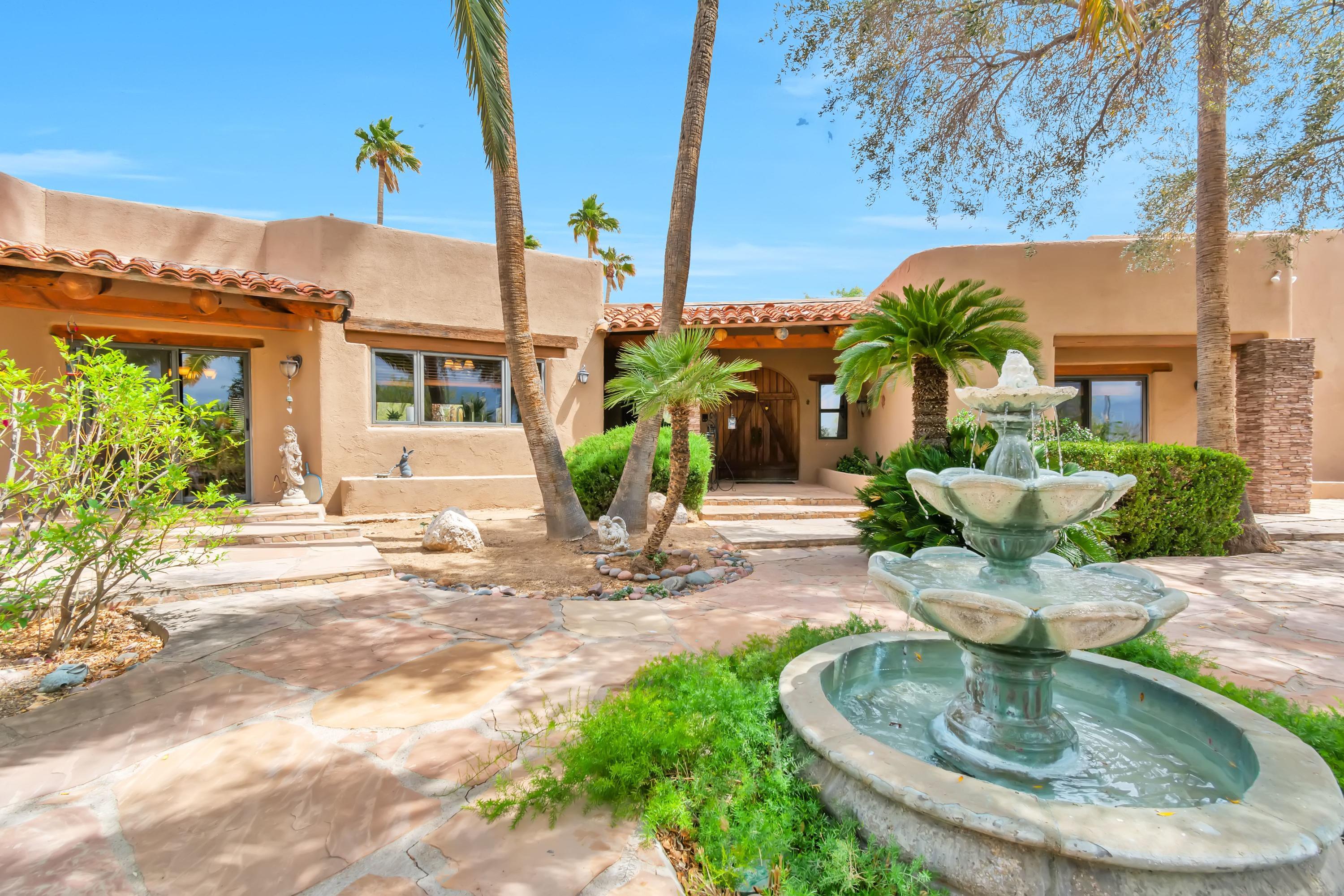 Spectacular Santa Fe! From the moment you enter the courtyard w/ fountain, thu massive Front door,  you feel the ''old world charm'' in a  newer remodeled setting.  The opulent living rm has huge  windows that  looks directly up to the awesome Catalina Mtns, every room has same view with patio doors to lovely patio, Raw pine Beams , unique ceilings thru-out, 3 Fireplaces. Lg, family rm/ kitchen , lots of beautiful cabinetry, island,   walk-in Pantry, stainless appliances , granite countertops, a gourmet cook's delight, 3 remodeled baths,  decorative travertine tile, granite counters. Huge covered flagstone patio, stone pillars , behive  fireplace, complete  outdoor kitchen, overlook sparkling pool , and the close mountains,  Separate  6-car garage, workshop. It's a family's private resort!