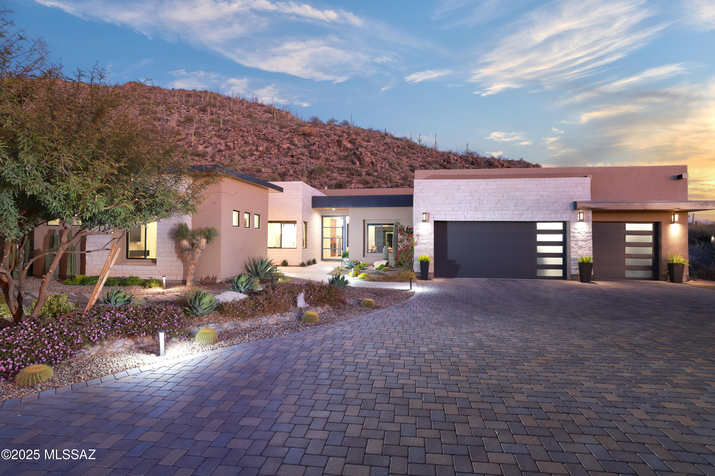 This virtually new home presents a rare opportunity to live in the exclusive gated Gallery Canyon estates next to the Gallery Golf Club, the premier 63-hole golf club in the Tucson area. Situated on 2.2+ acres, the home is nestled against the Tortolita hillside with views of the valley in the front, absolute privacy in the rear, and within very short walking distance to all club amenities. This home is unique for the desert, with calming designer touches throughout. As you enter, warm earth tones and walnut accents of a Pacific NW craftsman greet you, which fuse beautifully with the best of modern desert contemporary design: Glass barn doors, interior stone accent walls, 27' of Fleetwood pocket doors, Subzero and Wolf appliances (including 42'' Professional Series BBQ and 146 bottle dual- zone wine cooler), Nickels custom cabinets, Hubbardton Forge lighting, tankless water heater, water softener, spacious 2-room casita with separate entrance (pre-framed for interior access to main living area) and fully-equipped kitchenette, expansive covered patio areas, two-sided fireplace, pool, large superior grade putting green, color-infused designer landscaping, security system, and fully owned 14.88 KW solar system. Come visit and bring a blanket and pillow. You'll want to stay.