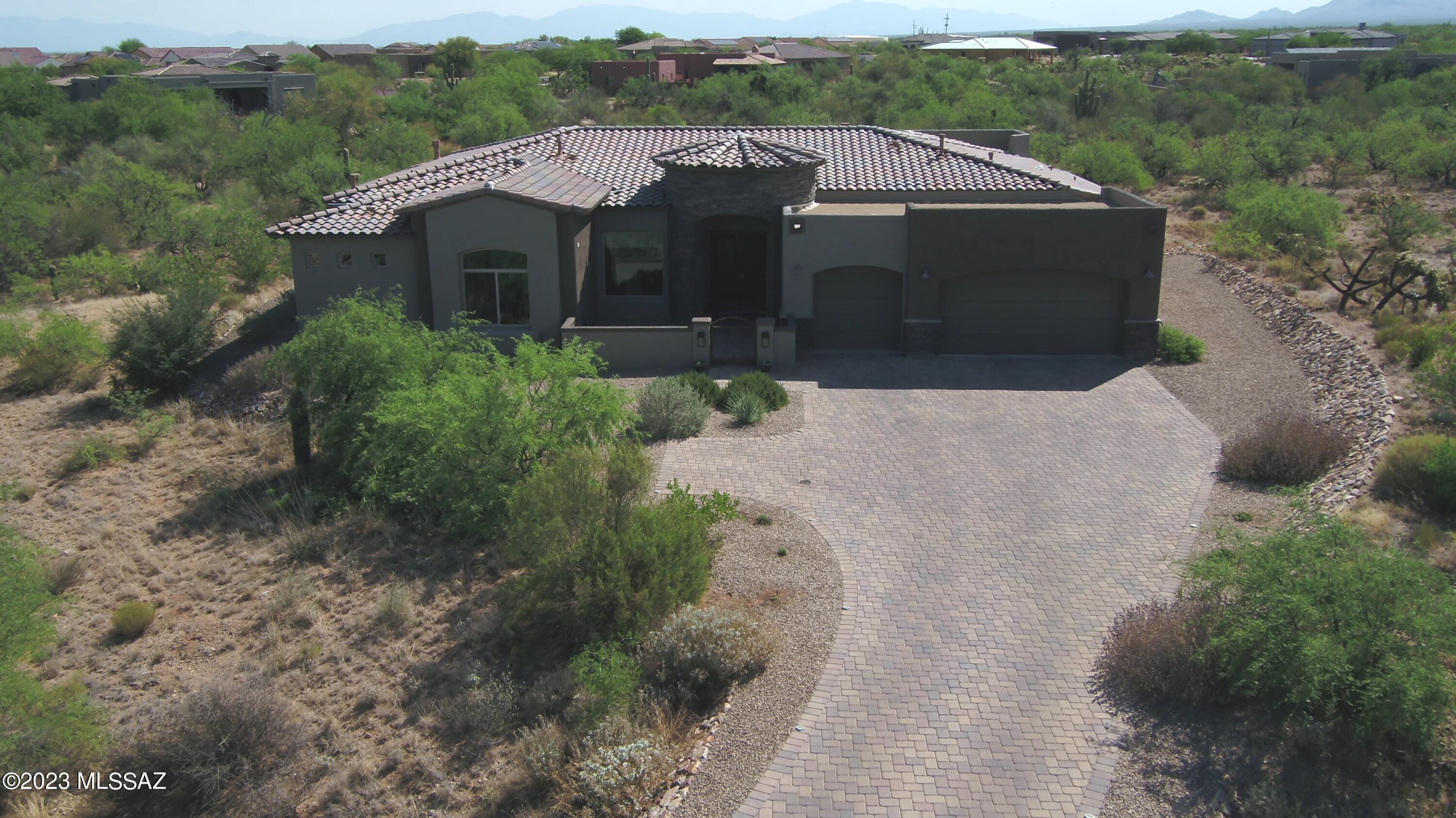 Gorgeous custom home in the highly desirable gated community of Stone House. Homes of this caliber do not come on the market often! Just 3 years young, this home is absolutely better than new! It's like getting a new construction house without the headaches, unexpected costs, supply chain issues or extended build times. Loaded with all the right upgrades, features include a premium 1.2 acre cul-de-sac lot, gourmet kitchen that is a chef's dream come true with a huge island, built in wall oven & microwave, gas cooktop and hood, large pantry, tons of cabinets, beautiful granite countertops, custom backsplash and a sunny dining area, plus a dining room. The family room off the kitchen and the living room both have stunning fireplaces with floor to ceiling tile. Split bedroom plan; Fabulous primary suite with an amazing oversized tiled walk-in shower, extended dual vanities with extra counterspace, center sitting spot, cabinets and drawers...TWO walk in closets, & a private door to the back patio. 2nd and 3rd bedrooms share an upgraded jack and jill bathroom. Den/4th bedroom has double doors and is adjacent to a full bathroom. Nice laundry room with sink, shelves and washer & dryer. Huge private backyard is professionally landscaped and has plenty of room to add a pool, sports court or whatever your heart desires. Custom outdoor built-in BBQ & additional patio area with gas firepit with clear views of the mountains, sunrises and sunsets...perfect for relaxing, entertaining and truly enjoying desert living. Lovely gated front courtyard. Spacious 3 car garage with plenty of room for storage. All that plus Alder wood doors throughout,  top-of-the line window coverings, a security system, surround sound prewire & solar prewire. Check out the video to see an overview of this home and the fabulous surrounding space. Call today for more details and to schedule a showing...don't miss out on this one!
