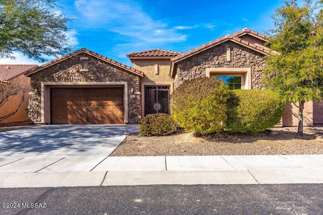 This gorgeous 4 bedroom/2.5 bath Pulte Home located in the gated Preserves III, is one of the larger homes in The Preserves. A beautiful courtyard lies behind the ornate gate as an entrance to the home. You enter the great room which  has a gas fireplace surrounded by a wall of stacked stone, a built-in entertainment center, a separate dining area and windows facing the natural preserve in the back yard.  The kitchen is a chefs dream.  Cabinets along the entire wall, a five burner gas top is located under a stainless steel vent, wine cooler, walk-in pantry and an oversize island with more storage.  The kitchen is large enough to have a separate eating area.   In the primary bedroom you have a closet to meet all you needs and wants.  Lastly, there is a separate one bay garage that you can design to meet your needs.  Storage for the sports car or a workout area.  A beautiful house in a lovely gated neighborhood.  Come take a look.