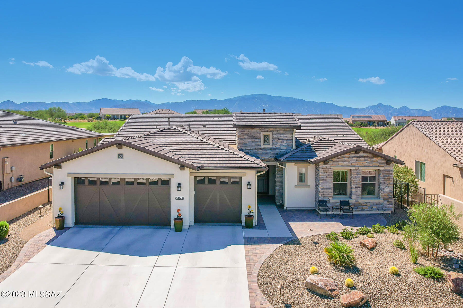 Spectacular, newer 2BD/2.5BA +Den (2,435 sq ft) Tesoro model boasts upgraded amenities, room extensions, dual en-suite bedrooms, front/rear paver patios, 3 car garage and panoramic mountain views. Home backs to common area with golf course beyond. Open concept plan features walls of windows plus Gourmet kitchen hosting center island with breakfast bar, dining nook, quartz countertops, GE Monogram appliances plus butler's pantry. Owner's Suite hosts a luxury bath with dual sink vanity, walk-in shower and dual walk-in closets. French door entry to large Den. Laundry with sink, central vac, fresh air system and green NAC water softener! Wonderful rear yard boasts covered patio with roll screen, gas firepit patio, decorative turf and gas BBQ. Saddlebrooke Ranch premier active adult community.