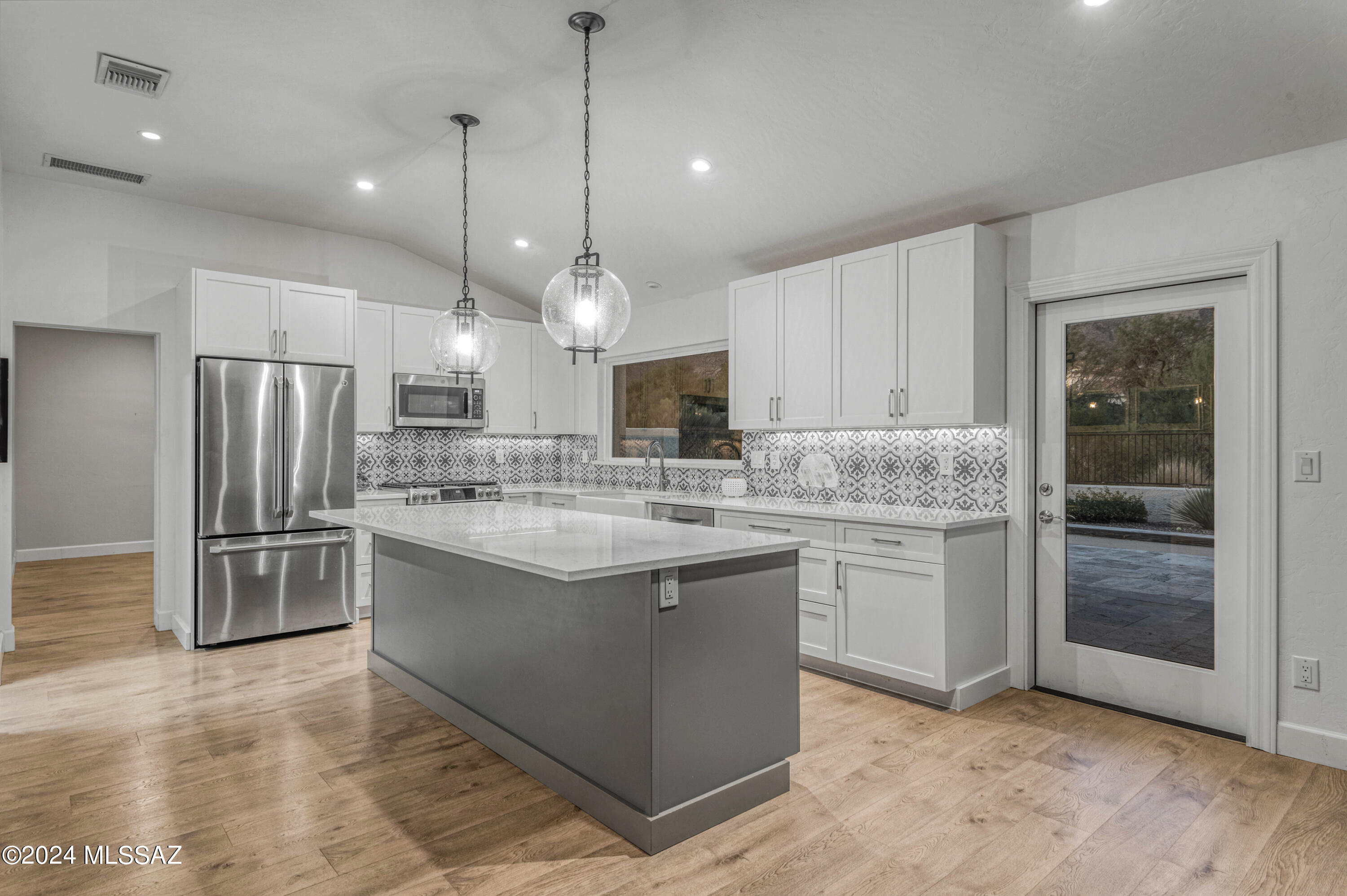 Nestled in the highly desirable Casas De Ventanas community, this exceptional one-story home features awe-inspiring panoramic views of the Catalina and Rincon Mountains. The spacious, open-concept design is highlighted by soaring ceilings and a gourmet chef's kitchen, complete with top-of-the-line stainless steel appliances and sleek quartz countertops. The luxurious primary suite serves as a private sanctuary, offering a spa-like bathroom, a generous walk-in closet, and direct access to the beautifully landscaped backyard. The well-appointed laundry room is a standout, with ample cabinet, drawer and counter space for ultimate organization. A custom-built gas fire pit creates an inviting atmosphere for relaxed gatherings, adding both warmth and sophistication to your outdoor living space.