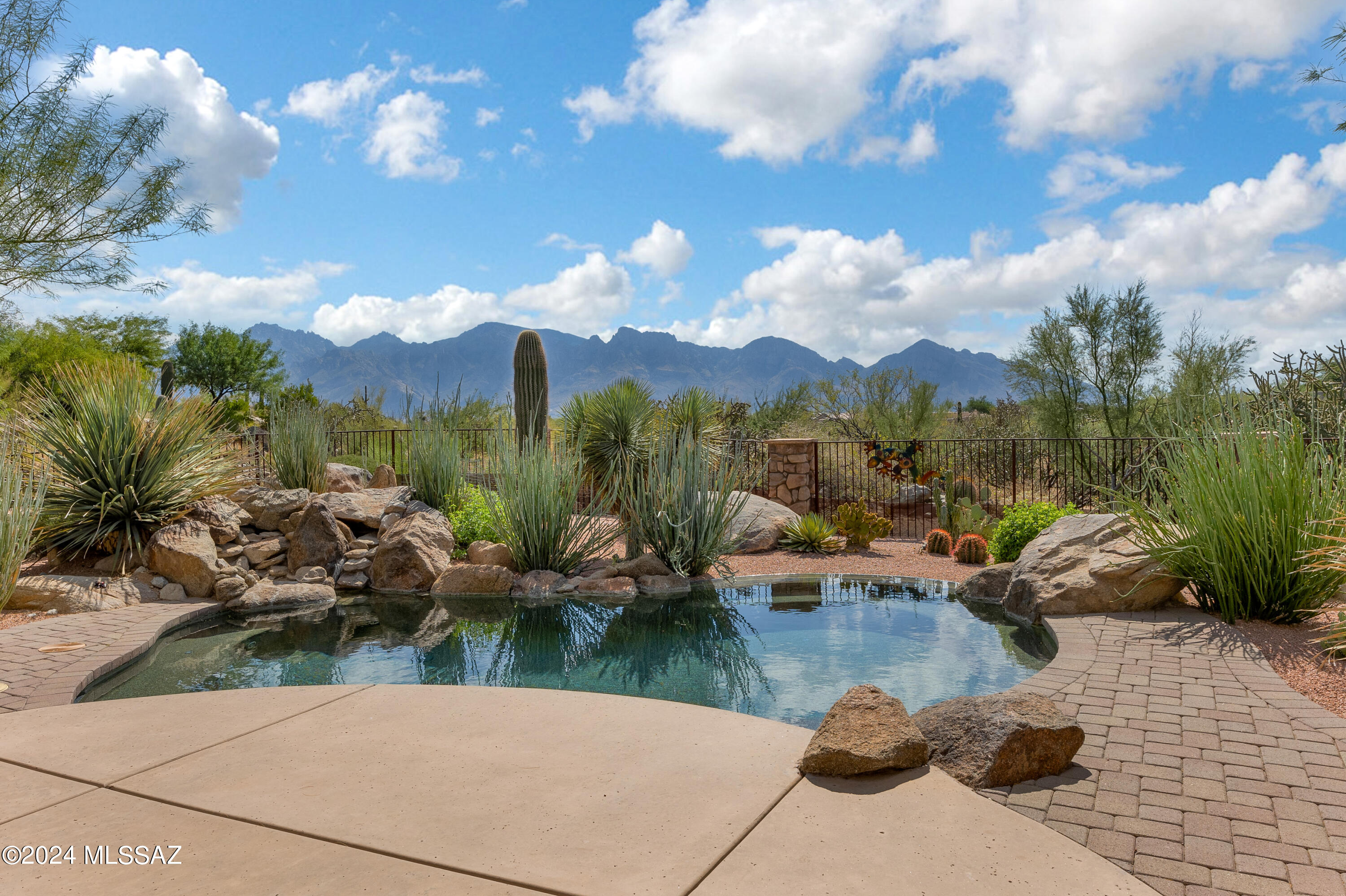 Stone Canyon, nestled against the picturesque Tortolita Mountains in the Town of Oro Valley. This private residential golf community boasts over 1,400 acres of breathtaking land and is highlighted by a Jay Morrish designed world-class 18 hole golf course. Stone Canyon is the only golf course in the greater Tucson area ever to be ranked in the TOP 100 golf courses in America according to Golf Digest. Accompanied by a luxurious health & fitness facility and modern restaurant & bar. Wonderfully upgraded and meticulously maintained, four bedroom, plus den/office, three bathroom, plus powder room home leaves nothing to be desired. Fabulous pavered driveway leads to beautifully landscaped front yard. Meticulous stone facade, entry courtyard. Fabulous mountain views from inside and outside. Property backs up to the Vistoso Trails Nature Preserve. Travertine flooring in main living spaces, no carpet, or interior steps. Smooth stucco exterior. Hunter Douglas Plantation shutters throughout. Four eight foot Pella sliding doors to exterior. Pella wood framed windows. Wonderful primary suite, plus two additional en suite guest spaces with walk-in showers, one with access to rear patio. Granite counter tops and dove tailed cabinetry in guest bathrooms. Open kitchen to great room with stacked stone entertainment nook with Alder cabinets and shelves, LED canned lighting with dimmers. Kitchen boasts KitchenAid double ovens, six burner gas cooktop, stainless steel exhaust hood, Bosch microwave, dove tailed solid wood cabinetry, walk-in pantry, two separate stainless steel beverage refrigerators with glass cabinet dry bar. Wonderful primary suite with access to rear patio. Primary bathroom with dual vanities, granite counter tops, walk-in shower, Jacuzzi bathtub, large walk-in closet with quality built in shelving. Laundry room with sink, cabinets and gas hook-up. Large water heater with re-circulating pump. Storage closet in the garage. Garage storage cabinets convey. July 2024;  Exterior of house painted by Abeyta Painting, 5 Year Warranty transferable.
 March 2024;  Pool Heater replaced with a Raypak-Avia Pool Heater.  Includes 2 year Warranty.  Installed by Boulton's Pool Service LLC.
 April 2023;  Replaced Grill with new built-in Delta Heat Gas Grill.  Installer was Flame Connection.  Delta Heat provides limited warranty, see warranty information.
 March 2023;  New wood flooring installed in all bedrooms.  Installed by National Carpet, Inc.  Limited Warranty from Mohawk Flooring.
 January 2022;  New Chamberland Garage Door Opener installed.  Installed by Always Open & Shut Garage Door Service.  Limited opener warranty, see warranty information.