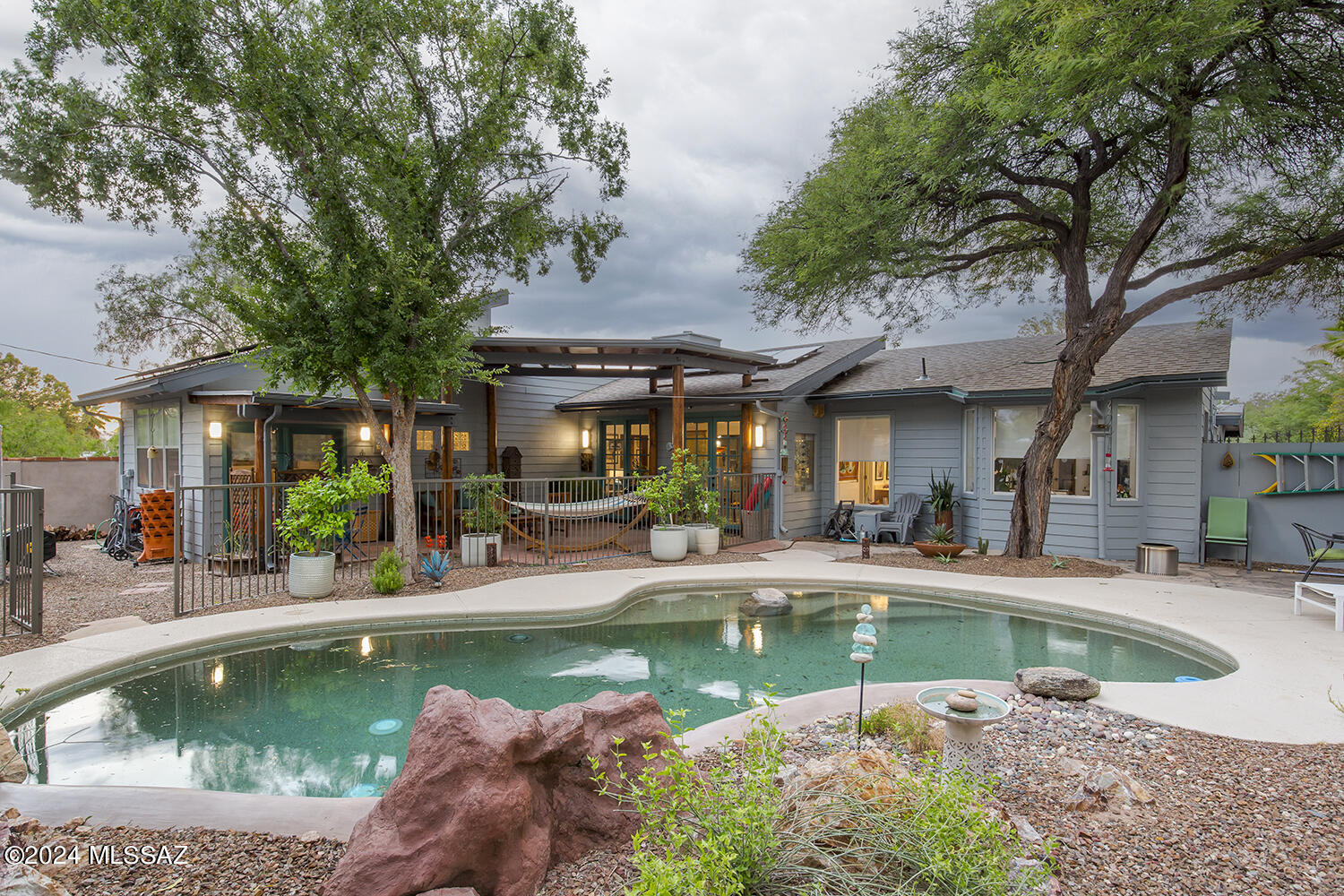 Your personal oasis awaits! You'll enjoy great entertaining space, indoors and out, in this magical 4-bedroom/3-bathroom expanded ranch in the historic
and much sought-after Blenman-Elm Neighborhood. Your primary suite has vaulted and beamed pine ceiling with celestory windows, private bath, gas fireplace, and French doors opening onto the brick patio and pool beyond. Your living room has a wood-burning fireplace, and your kitchen is a chef's delight!
This home is convenient to downtown and UA activities, Banner Hosp — even walking or biking — yet provides a quiet, private retreat at the end of your workday! You deserve this!
This beautiful home offers tranquility, energy efficiency through rooftop solar panels which generate enough electricity to cut TEP bills by more than half! Interior Highlights:
Chef's Kitchen: Boasting quartz and recycled glass countertops, fine European-style cabinetry, stainless steel appliances with a convection oven, a 5-burner gas cooktop, and a glass tile backsplash. The open design ensures great flow to the living and dining rooms.
Master Suite/Guest Suite: With a separate entry, this space includes a kitchenette, a fireplace, and French doors leading to the patio.
Flooring: New plank and carpet flooring throughout.
Fireplace: Bedroom chimney rewalled and recapped by Flame Connection, log set installed in the fireplace, and the unit brought into workable order in 2020.
Heating and Cooling: Two heat pumps and smart thermostats installed in 2021, replacing the old gas furnaces. The system is serviced annually.
Laundry: Energy-efficient stack laundry added in 2021.
Ceiling Fans: A modern ceiling fan installed in the front bedroom in 2021.
Water Systems: A whole-house water softener system installed with reverse osmosis in the kitchen in 2022, serviced annually, with the last service on 7/1/24.
Bathrooms: The bathroom off the dining room was remodeled in 2022, with the old shower and jacuzzi replaced by a European BanUltra tub with Chromotherapy, custom ordered through Benjamin's Plumbing. Custom shades were also installed in the large window and adjoining studio/bedroom bay windows.
Window Treatments: New blinds in the primary bedroom and adjacent hallway. Celestial window shades are motorized and operated by remote control, installed in 2023.
Lighting: A dining pendant light replaced the ceiling fan without a light in 2024.
Exterior Highlights:
Outdoor Living: Enjoy outdoor living with a covered patio, pebble tec pool, and natural mature landscaping.
Landscaping: Native plants and irrigation added for low-maintenance landscaping in 2021. 
Guttering: Guttering and directed water distribution added in 2022.
Wall Finishes: The wall along the back and western side of the yard was professionally finished with decorative cement in 2023.
Exterior Maintenance: The exterior of the house was sealed, repaired as needed, and painted in 2024.
Roof: A new roof is being installed in 2024.
Solar Panels: Solar panels installed in 2020.

Chronological List of Updates:
2020:
Bedroom chimney rewalled and recapped by Flame Connection. Log set installed in the fireplace, and the unit brought into workable order.
Solar panels installed.
2021:
Two heat pumps and smart thermostats installed, replacing gas furnaces. Serviced annually.
Energy-efficient stack laundry added.
New modern ceiling fan in the front bedroom.
Native plants and irrigation added for low-maintenance landscaping in the front and rear yards.
2022:
Whole-house water softener system installed with reverse osmosis in the kitchen. Serviced annually. Last serviced on 7/1/24.
Bathroom off the dining room remodeled. Old shower and jacuzzi removed and replaced with Chromotherapy BanUltra tub special ordered through Benjamin's Plumbing.
Custom shade installed in the large window of the remodeled bathroom and the adjoining studio/bedroom bay windows.
Guttering and directed water distribution added.
2023:
New blinds installed in the primary bedroom and adjacent hallway. Celestial window shades are motorized and operated by remote control.
Wall along the back and western side of the yard professionally finished with decorative cement.
2024:
Exterior of the house sealed, repaired as needed, and painted.
Dining pendant light added, replacing the ceiling fan without a light.
New roof being installed.