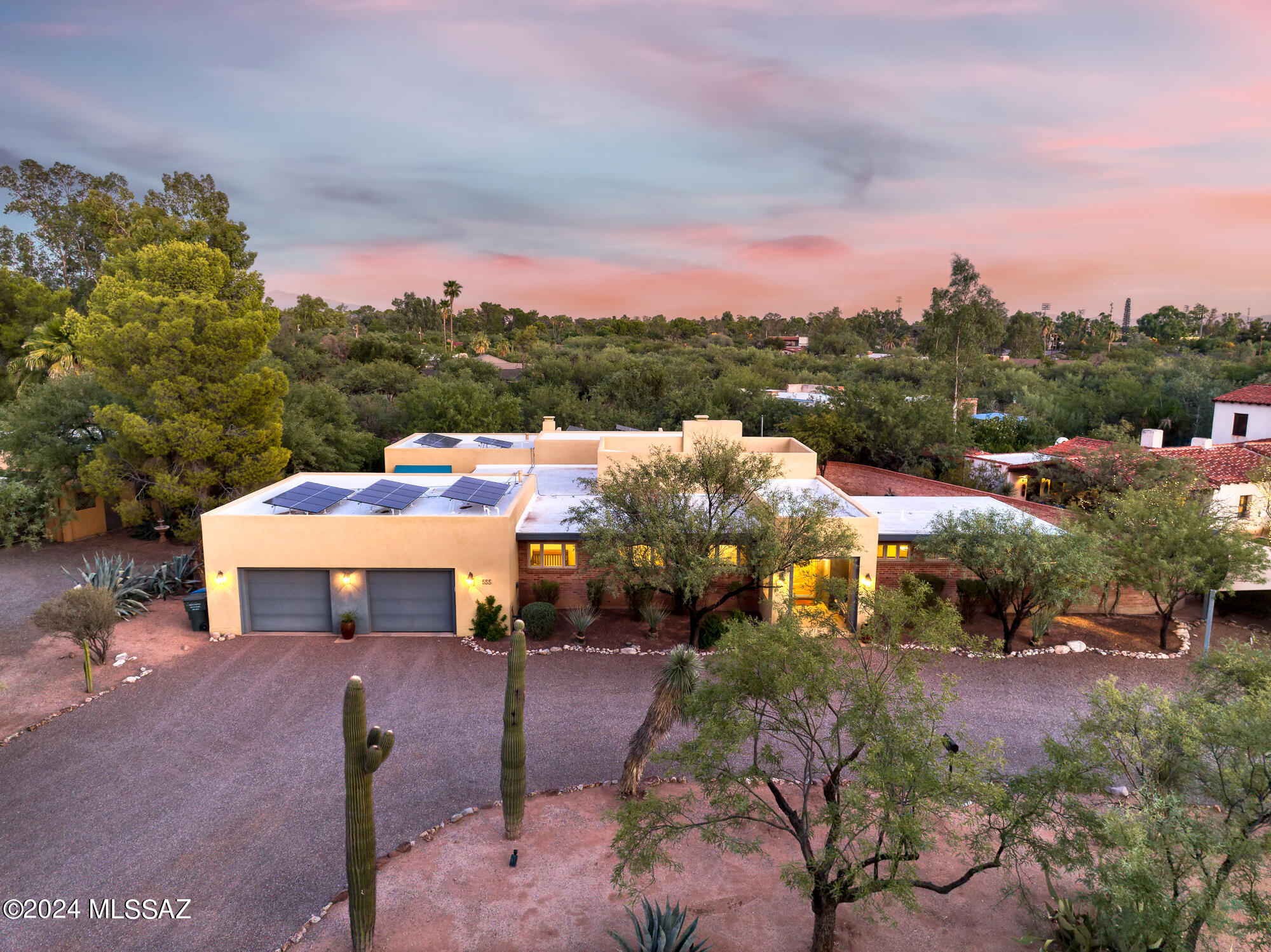 Step into this beautifully modernized residence originally designed by architect Merritt Starkweather, known for the iconic Arizona Inn. The open-concept layout showcases a spacious great room with a cozy fireplace, offering stunning views of both an elegant interior courtyard and an expansive covered patio with an outdoor kitchen and inviting pool, framed by large windows. The gourmet kitchen is a chef's dream, featuring top-of-the-line Viking and Sub-Zero appliances, including a six-burner cooktop with a griddle, pot filler, three ovens, and a microwave. An island bar with a vegetable sink makes meal prep a delight. A separate wet bar, complete with a wine cooler and additional storage, leads to a generously sized laundry room equipped with a second refrigerator...(continued) and ample cabinetry. The primary suite serves as a luxurious retreat, boasting its own fireplace, multiple seating areas, and even a dedicated office space. The ensuite bath offers a spa-like experience with a soaking tub, large steam shower with a bench, double vanities, and a spacious walk-in closet. This thoughtfully designed split floor plan includes a second primary bedroom with its own ensuite bathroom and direct pool access, along with two additional bedrooms that share a Jack and Jill bathroom. Throughout the home, polished caramel-colored concrete floors, natural stone, and glass mosaics create a harmonious and neutral aesthetic. A versatile family room, currently used as an office, features a Murphy bed for guests and can easily transform into a fifth bedroom, as it is adjacent to a full bathroom with a 2nd steam shower. It also has direct access to the enchanting interior courtyard, complete with a fountain, a covered patio with misters, and a stunning mural by artist Rocky Martinez. High ceilings, clerestory windows, dual-pane glass walls, and abundant natural light enhance this home's inviting atmosphere. The private backyard oasis includes an outdoor fireplace, covered patio spaces, a Pebble Tec pool with removable safety fencing, and an outdoor kitchen with BBQ and sink. For additional storage, a convenient 8x10 shed is located at the back of the property. With owned solar panels and batteries (not back-up for when power goes out, but helps with lower electricity bills and carbon footprint), you'll enjoy nearly net-zero utility costs year-round. An oversized two-car garage with epoxy flooring, plus two covered guest parking spots complete this exceptional .41-acre property. Don't miss the chance to make this stunning home your own in this charming historic neighborhood!