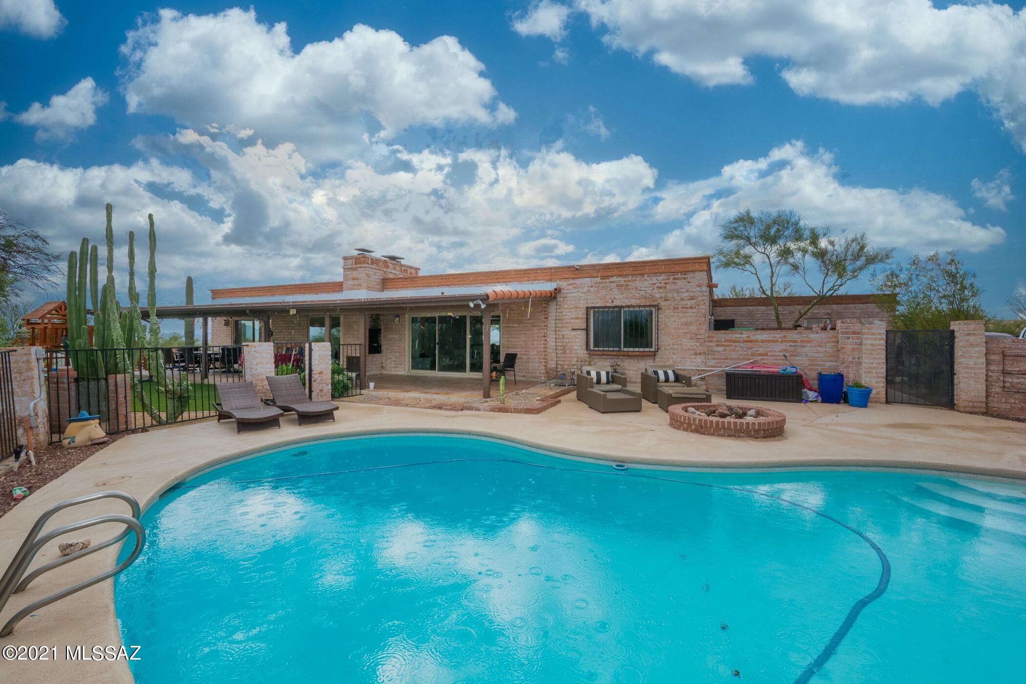 This Classic Burnt Adobe home in Catalina Foothill #7 is on a private lot and has  been nicely updated. The house is surrounded by large window that beautifully frames amazing city lights. Spectacular mountain views awaits you while enjoying the pool and the lush desert landscape. The kitchen has S/S appliance, center island, a huge walking pantry,  a comfortable seating and gathering area. Open floor plan with an elegant dining room with a fireplace that opens into the formal living room with beamed ceilings. A split bedroom plan.  The master has its own patio, two closets, dual sinks and walk in shower. Large covered patio is great for entertaing year round, artificial turf, play area, pool with a slide. Convenient to U of A, shopping, dining, parks and Rillito River Walk.