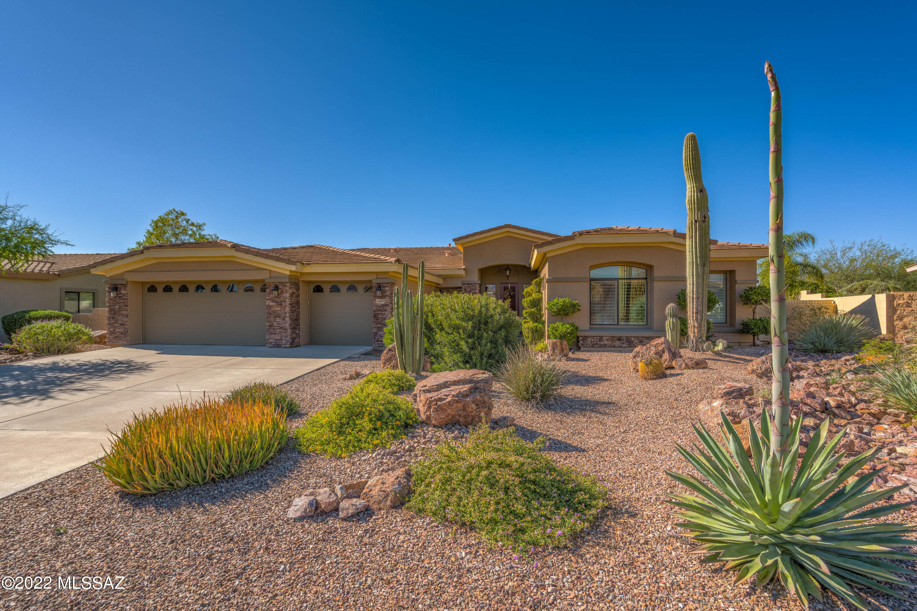 Spectacular 4BD/2.5BA (3,316 sq ft) home on large lot in the heart of Oro Valley boasts formal & informal living, architectural details, natural stone flooring and resort-style yard w/pool. Backs to common area for ultimate privacy. Cozy stacked stone fireplace highlights Great room w/gourmet kitchen hosting center island w/bar, dining nook, granite counters & stainless appliances including gas cooktop, built-in oven & microwave. Split bedroom plan offers a spacious Owner's suite w/walls of windows plus luxury bath hosting jetted tub and walk-in shower & closet. Outdoor oasis features a rear covered patio w/slate tile, lush lawn and spectacular heated pool w/oversize raised spa and tall rock waterfall w/slide. Plantation shutters, slate tile entry, 3 car garage plus newer HVAC. A must see!