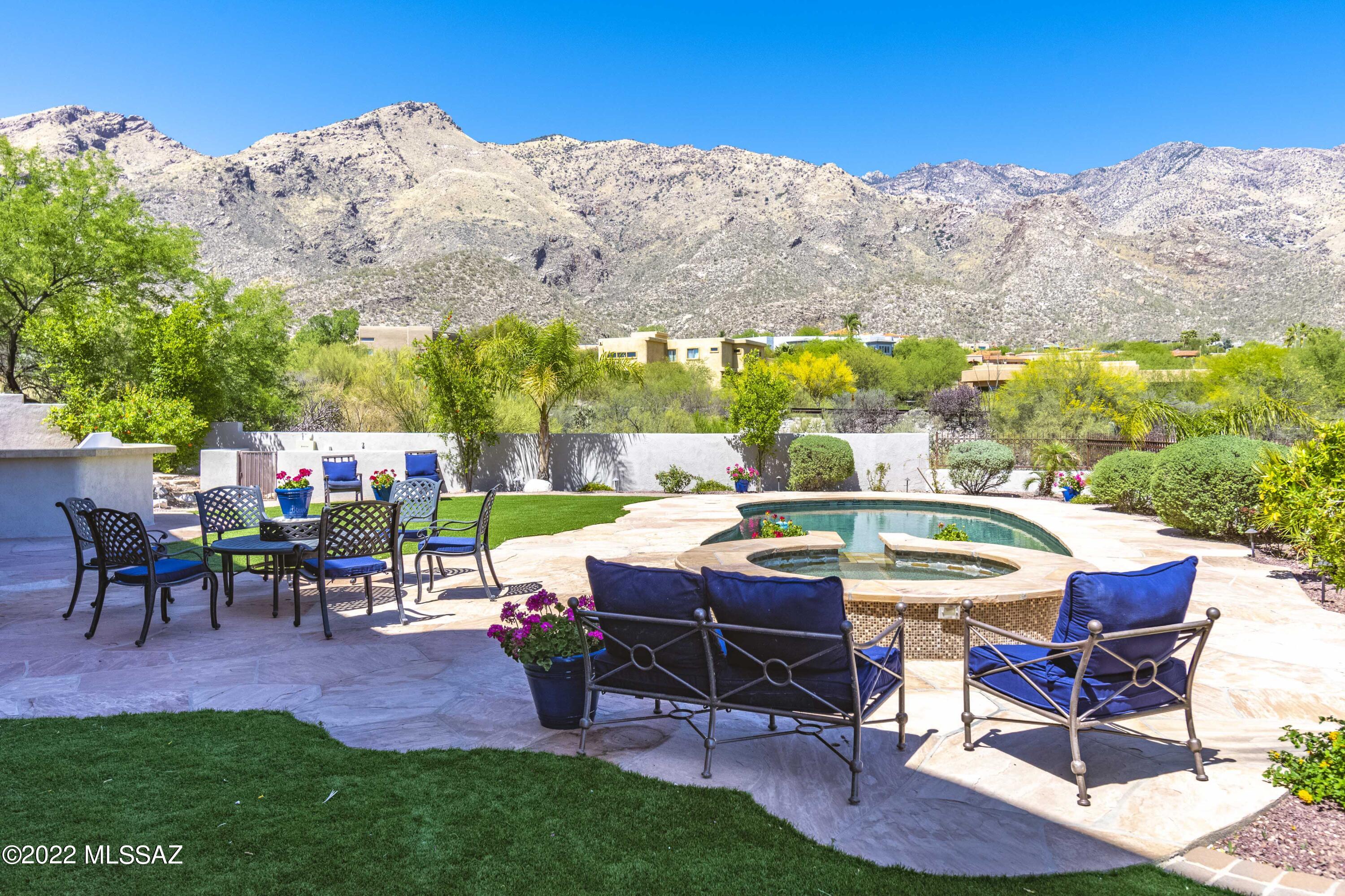 Step into a world of views. Every main room has close up stunning mountain views. This contemporary designed home has beamed ceilings in the great room and touches of natural stone in all the right places. Upstairs has 4 bedrooms with ensuite baths and closets. Downstairs has an in-laws or kids area with a full kitchen/great room, fireplace 2 bedrooms and 2 baths. A true multi-generational plan. Walk-out to the pool and resort style backyard with the mountains as the back drop. Upstairs there is a north facing balcony the entire length of the home. Truly breathtaking setting and convenient to the best the Catalina Foothills has to offer. The flexible floor plan can suit many needs for an office/workout spaces.  HOA hosts various social clubs & 24 hr security patrol.  Fractional ownership?