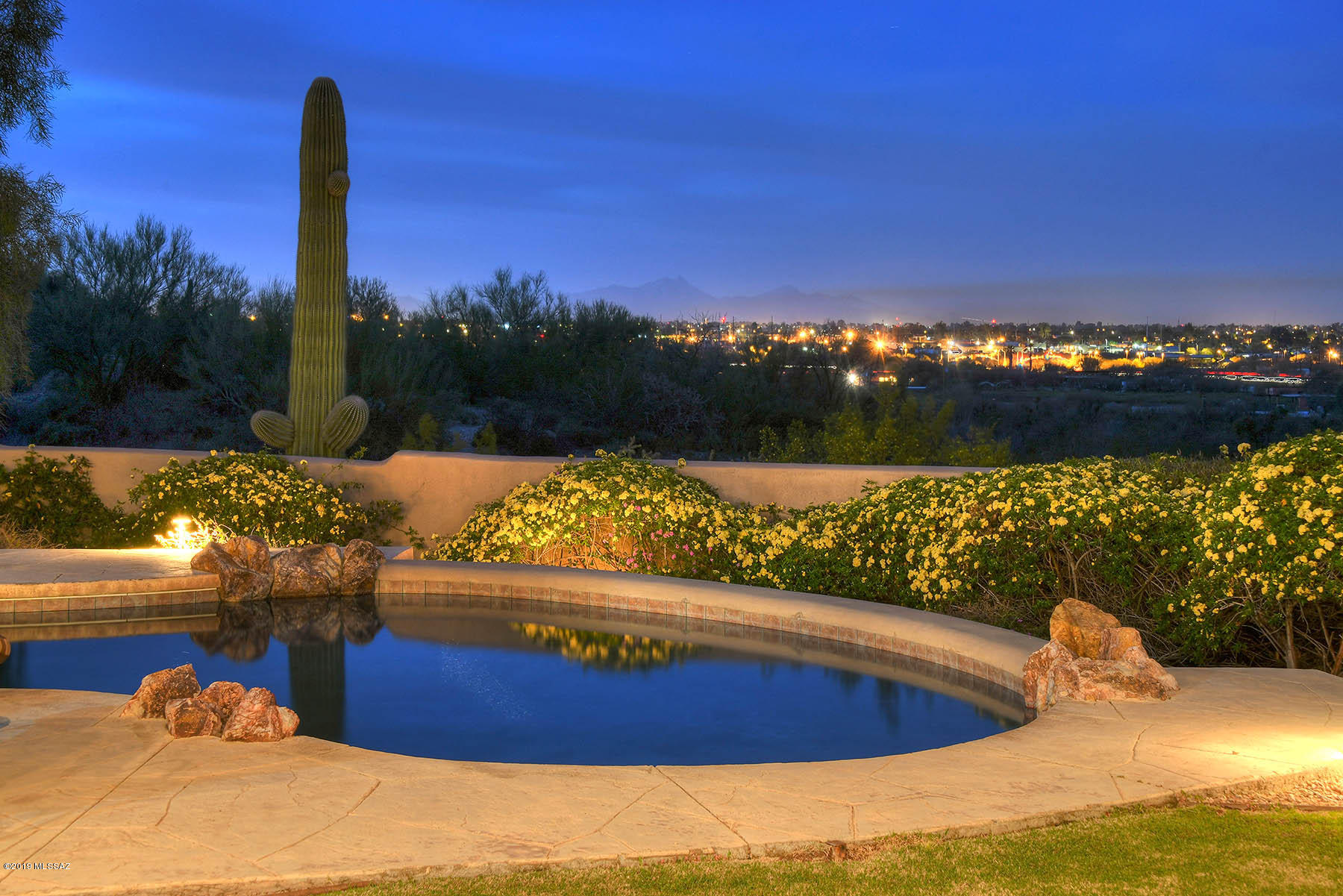 THIS HOME HAS IT ALL, GATED,COMMANDING CITY LIGHTS AND MOUNTAIN VIEWS CAPTURED THROUGH THE LARGE PICTURE WINDOWS, HOME SITS ON .8 ACRES ADJOINGING 2 ACRES OF NATURAL DESERT COMMON AREA. CLOSE TO EVERYTHING YET AWAY FROM IT ALL. THIS HOME FEATURES NEW KITCHEN W/CENTER ISLAND, 4 BEDROOMS WITH WALK-IN CLOSETS, 2 3/4 BATHS. 4TH BEDROOM OFFICE LIBRARY. SOARING CEILINGS AND SKYLIGHTS. 2 FIREPLACES, POOL SPA  BUILT IN BBQ, FIRE PIT, SELLERS ARE LICENSED AGENTS IN THE STATE OF ARIZONA.