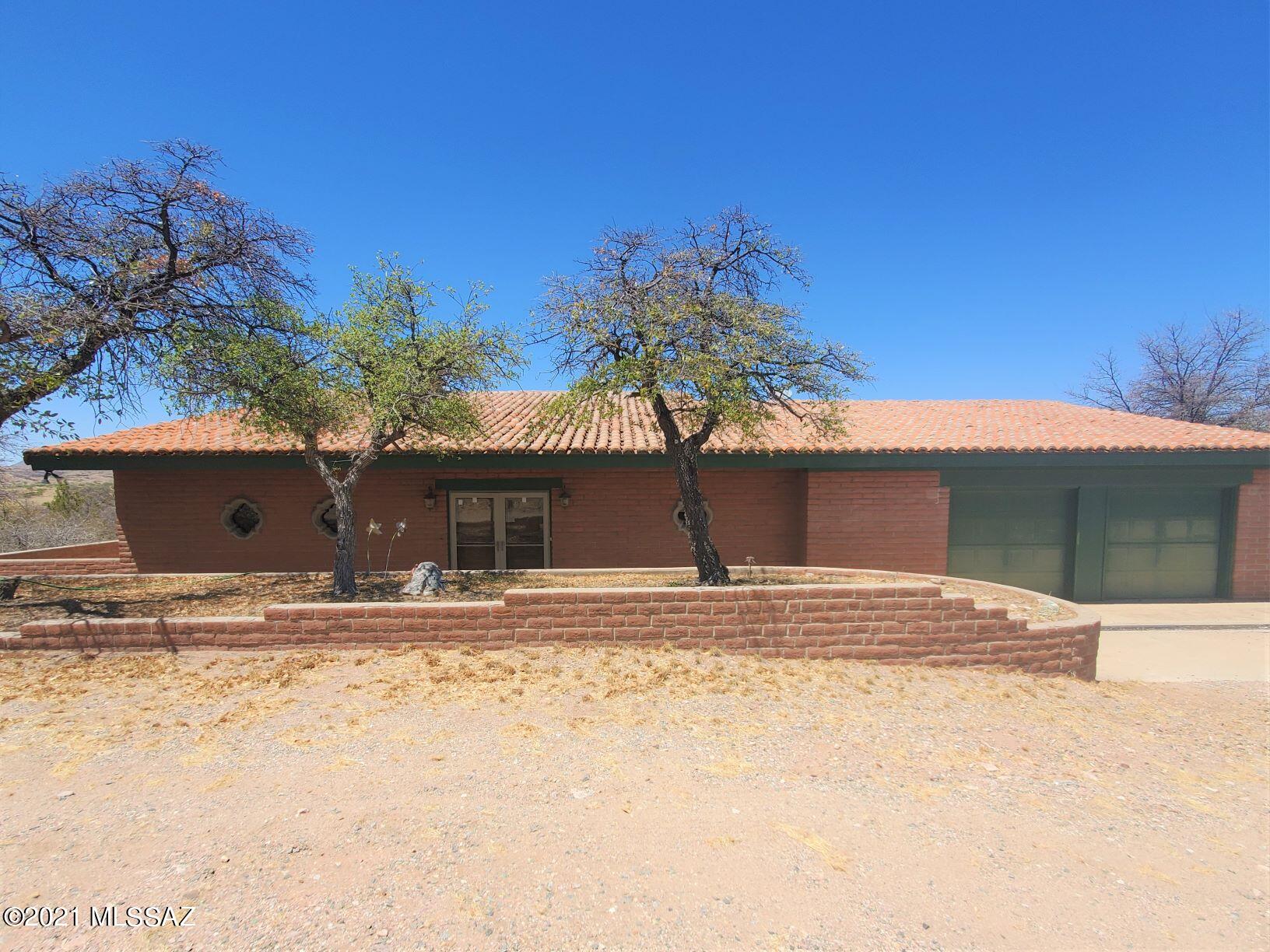 Price includes both house AND vacant lot next door! The home is situated in the Casas Arroyo subdivision which has a limited number of homes nestled among ~200 acres of Sonoita's picturesque rolling hills and oak trees. This 2BD/2.5BA home has a large kitchen with center island and ample storage, vaulted ceilings, exposed beams and other unique architectural features. Newer sliding glass doors provide plenty of natural light and showcase amazing mountain views of the Santa Ritas. Large MBR has a fireplace, jetted Jacuzzi tub and walk-in closet. 2nd BR has its own attached bathroom w/ shower.  A charming den overlooks the step-down living room featuring a dramatic fireplace.   On hot days, you can cool down at the community pool