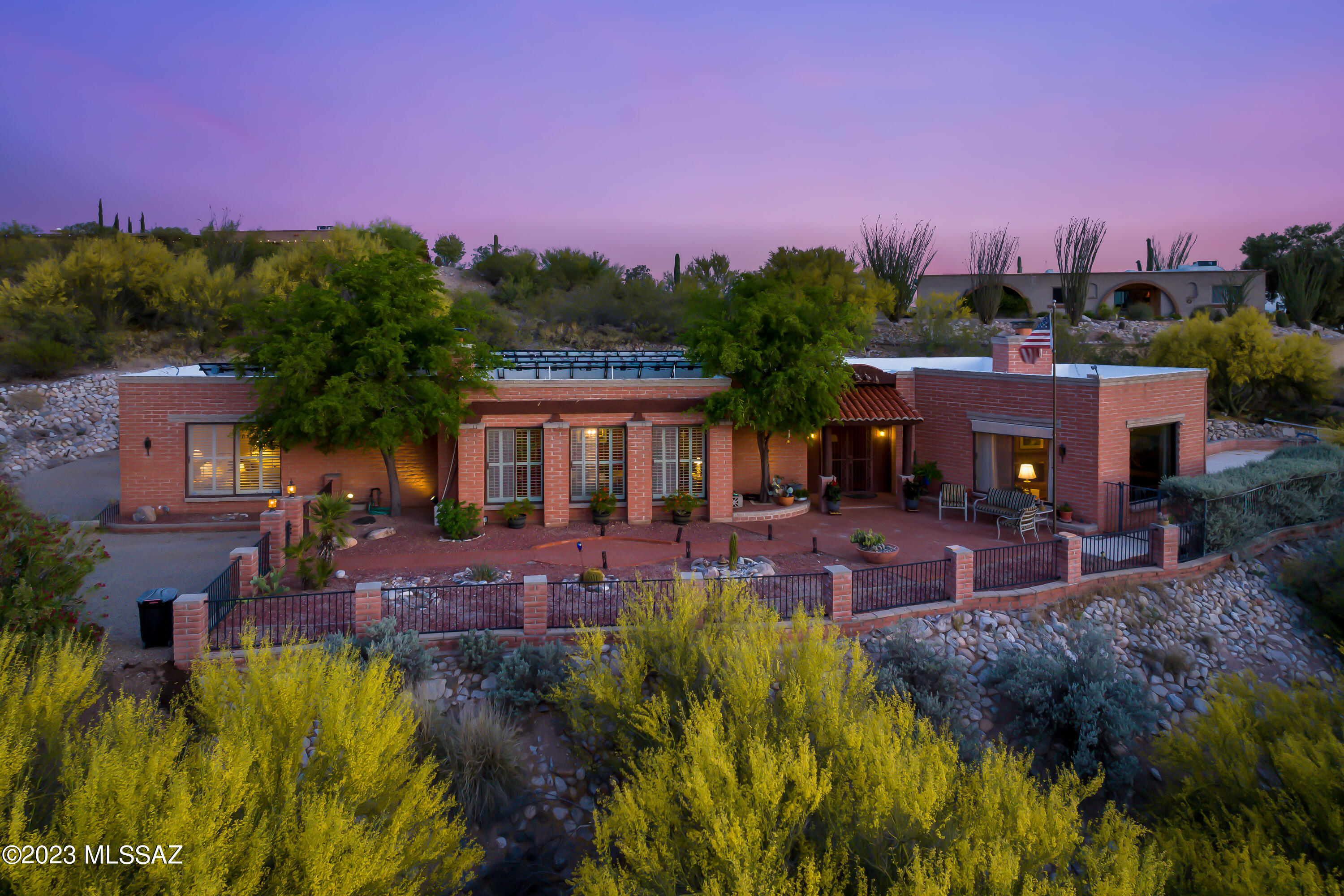 Fabulous Territorial home situated on an elevated hillside lot with unobstructed Catalina Mountain views. Enter through the large courtyard to this unique home featuring a spacious living room with large picture windows and a 3-sided brick fireplace. Expansive separate dining area boast a wood burning fireplace, a wall of windows and is ideal for entertaining or making memories with friends or family. The spacious updated kitchen offers granite counters, prep sink, a breakfast bar, that opens to a large family room.. Additional features include diamond shaped Saltillo floors, skylights, fully OWNED SOLAR, and an expansive garage and plenty of storage. Private backyard is ideal to relax by the pool or under the covered patio and watch the colorful Arizona sunsets the Catalina Mountains. Skylights throughout main areas bring in tons of light. Take your favorite cocktail and relax by the saltwater pool or under the oversized covered patio and watch the colorful Arizona sunsets. All this plus OWNER OWNED SOLAR, 2 car garage, storage room and plenty of parking.
