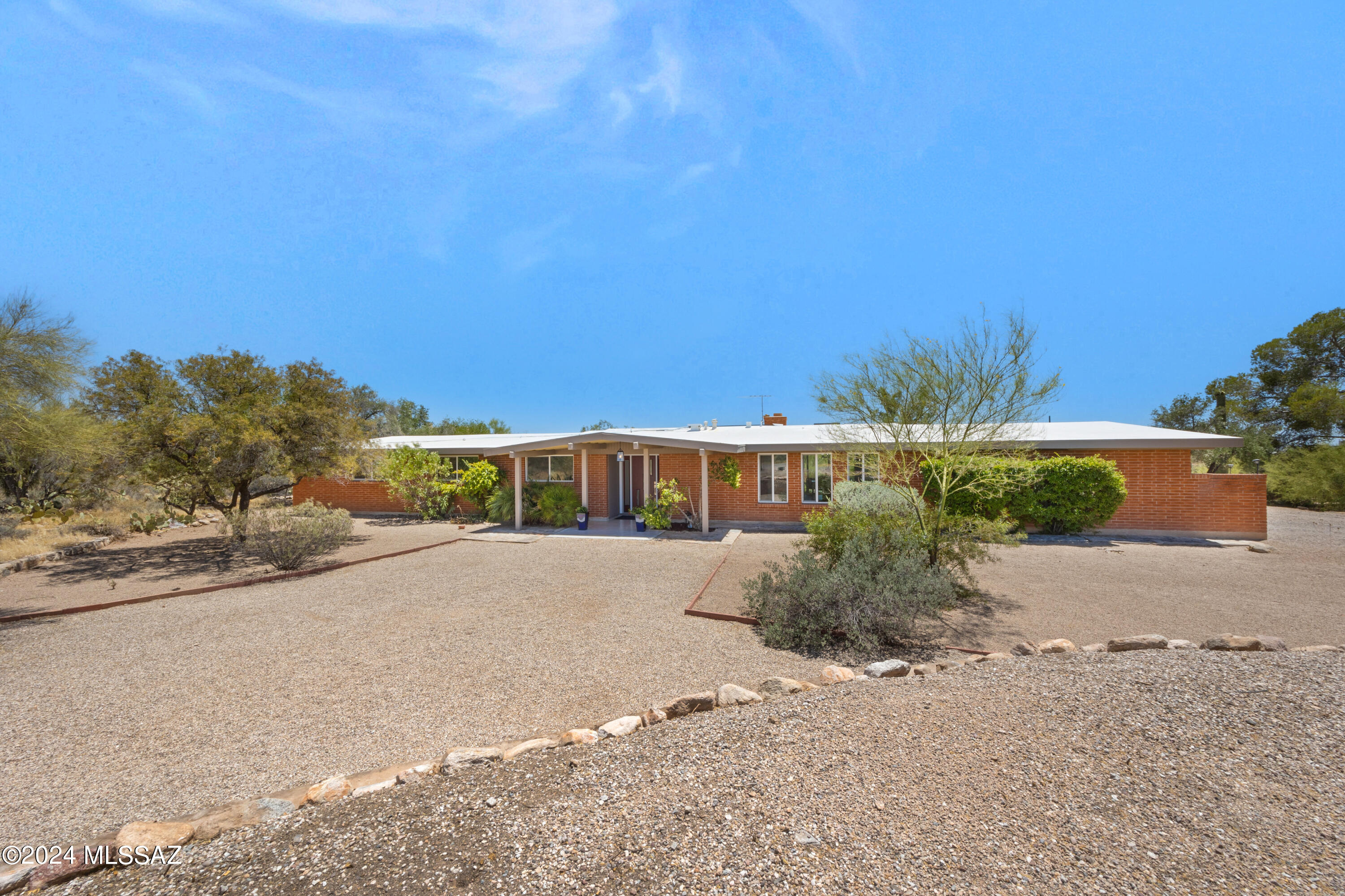 Stunning Oracle Foothills Ranch Home w/ Sparkling Pool & Desert, Mountain & City Views! 2,526 SqFt, 3Bd/2Ba+Bonus Room. Fully Renovated in 2024.  Timeless Red Brick Construction, Vaulted Wood-Beamed Ceilings, Wood-Burning Fireplace, French Sliding Doors, Picture Windows & Stranded Bamboo Floors. Gorgeous Kitchen w/ Quartz Countertops, Soft-Close Cabinets-42'' Uppers w/ Crown, Dual Fuel Pro Gas Range, Mega Capacity Fridge, Vent Hood, Apron Front Sink, Peninsula & Beverage Nook. Minka Lighting. Large Owner's Suite w/ Sitting Area & 2 Closets. Dual Sink Vanities in Washed Walnut w/ Quartz Tops. Custom Tiled Showers. New Roof in 2021. Highly Efficient 2017/2018 Gas Split System. Sparkling Pool, Covered Patio, Flower Beds & Great Views! .82 Acre Lot. Impressive Home & Exceptional Location!