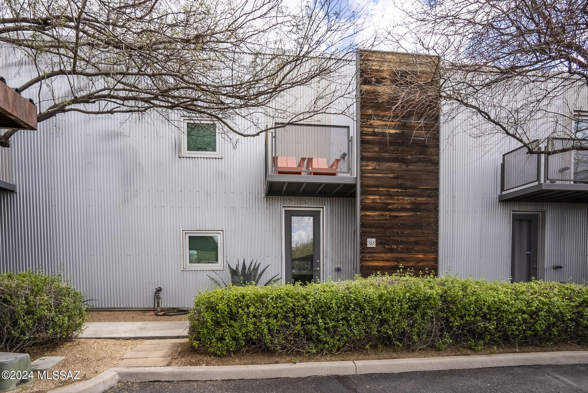 Located in the historic 1923 Arizona Ice and Cold Storage Company building, this spacious Tucson Ice House loft-style condominium features contemporary space that beautifully preserves the structure's authentic industrial character. Featuring an exceptional location close to area recreation, nightlife and the University of Arizona, the home includes onsite amenities such as a community pool and fitness studio, along with resident storage. Light-filled interior features modern design details including hardwood flooring and upgraded fixtures and finishes, including reclaimed elements from the building's renovation. Generously scaled outdoor space includes a balcony adjoining the owner's suite and a private fenced backyard with greenspace and hardscape, ideal outdoor dining and entertaining.