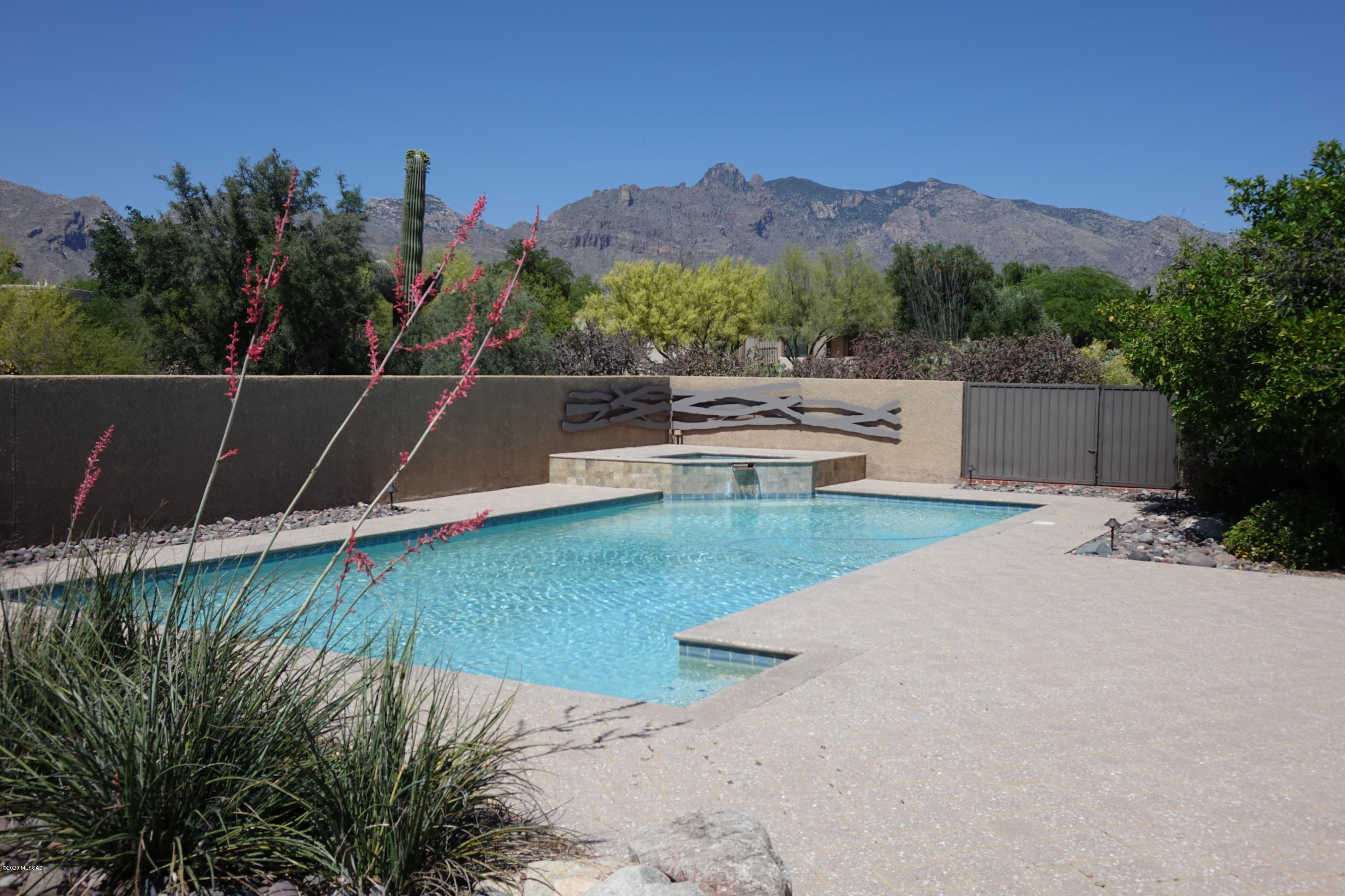 Enjoy the summer relaxing by this sparkling pool and spa. District 16 schools and storage galore. The master bedroom has a fireplace and a huge walk-in closet. The extra-large bonus room offers endless possibilities for the hobbyist or for extended family living. All four bathrooms have been beautifully updated. The kitchen includes granite counter tops and a warming oven. The office area has built-in desk and cabinets. The private backyard has a magnificent view of the Catalina Mountains with a play/lap pool, spa, huge deck area and artificial turf for easy care. A retractable fence is also included. A three-car garage includes an additional storage/work room.  Just minutes to schools, shopping, restaurants and the U of A.  Agent is related to the seller.