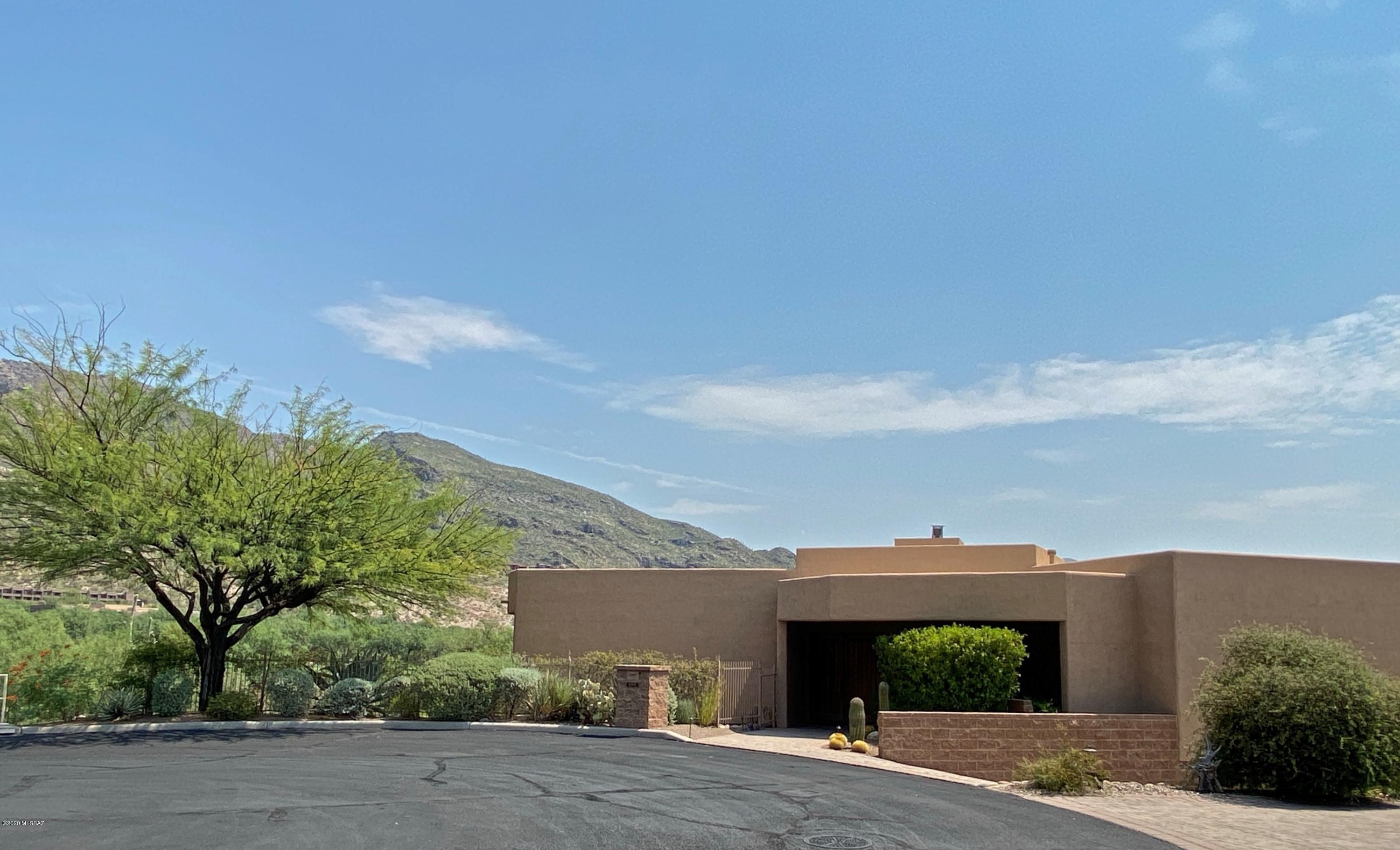 Iconic home in Catalina Foothills with breathtaking views.  Contemporary style home located in gated, private cul-de-sac. Open and light with walls of glass, gourmet kitchen, granite counters, stainless appliances, gas cooktop and walk-in pantry.  Extras include media/game room with sink and refrigerator,  two way fireplace, Master BR built in furniture, Travertine, Select Wood floors throughout. Master Bedroom and main living area are on the same level. Upscale home has top-of-the-line window treatments including rolling shutters on all windows, state-of-the-art Home Automation Control 4 System, surround sound, media components, newer 16 Seer HVAC, brick paver driveway, ''spool'' + water feature, all in immaculate move-in condition.