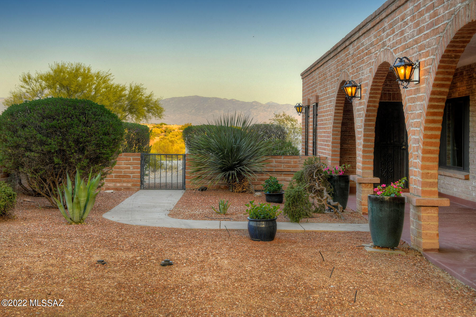 Rare gem with premier location & 360 VIEWS!  Solid burnt adobe, arched entry, beamed ceilings & hand-forged iron accents blend with tasteful upgrades like granite, wood & tile flooring to exude warmth and charm that is quintessential Tucson. Ridgetop location & driveway setback offers privacy with large front courtyard capturing stunning Catalina Mountain views incl. Finger Rock while south patio overlooks pool & sweeping city lights below. Family room features beehive fireplace and opens to kitchen. Primary bedroom has a wood-burning fireplace & bonus space used as an artist studio. 4th bedroom is split plan - perfect as guest suite or second master. Great flow, 1+ acre in coveted heart of the Foothills. Close to some of Tucson's best shopping & dining. 2-car garage. Pool. Voluntary HOA.