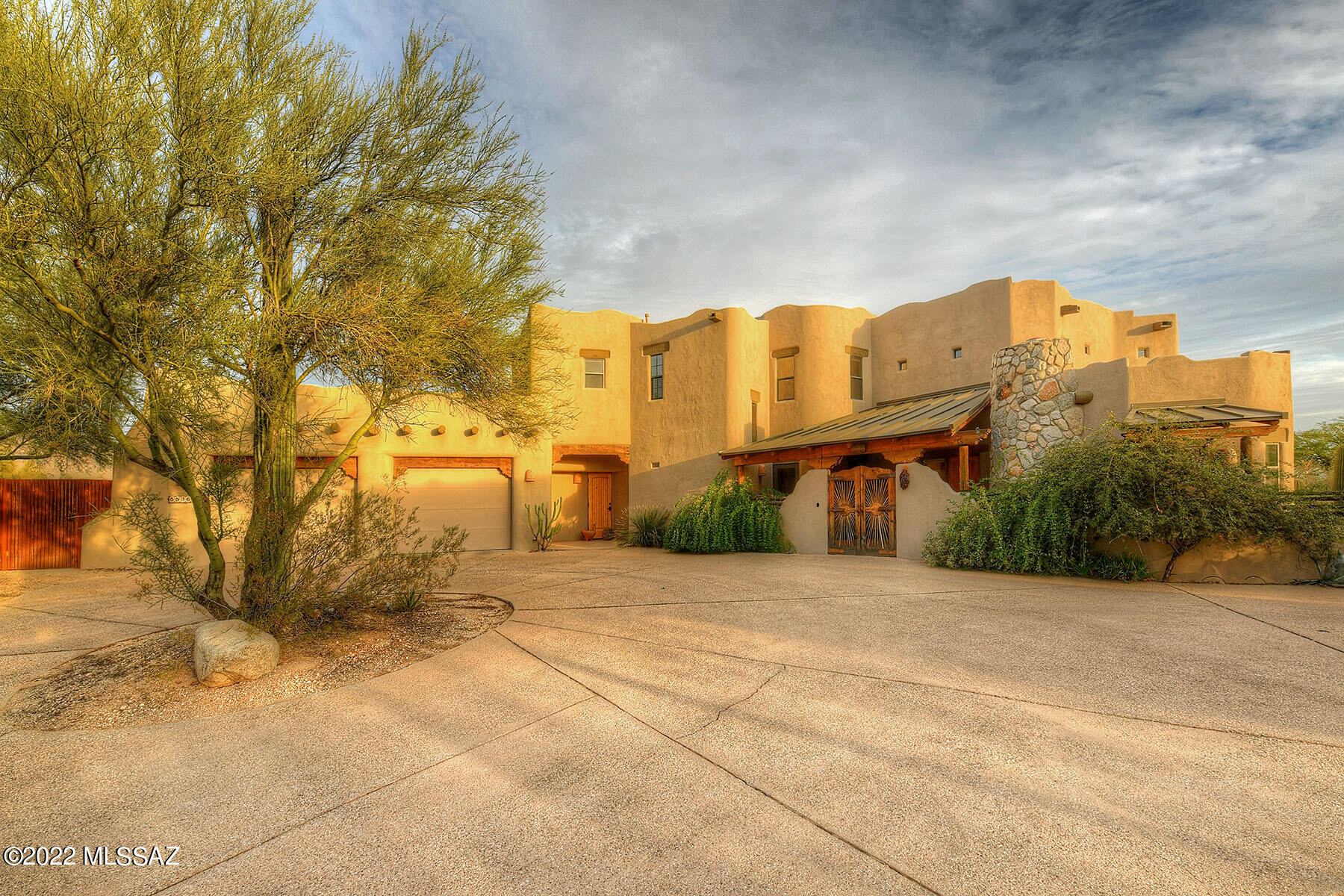 Spectacular City and Mountain views in every direction from this special custom hilltop Santa Fe home.  Amazing wood beam ceilings, Saguaro rib accents and Pine columns.  Flagstone floors and fabulous Southwest  details throughout!  Lovely courtyard entry welcomes you into the amazing great room with walls of windows providing abundant natural light.  A towering 2-way fireplace serves both the great room and detached formal dining area.  Spacious kitchen offers an induction cooktop, large work island and pantry storage.  The primary suite features a fireplace, private wrap around balcony, dual sinks and a walk-in shower.  Upstairs bedrooms 2/3 share a deck with outstanding mountain views.  Bedroom 4 has western city and mountain views.  The main floor has an ensuite bedroom. Off the kitchen you'll find a spacious laundry room.  Outside you will find a fabulous metal patio/deck, 12x24 finished RV garage, banco seating & kiva FP.  Downstairs guest suite has its own fireplace and bathroom.  Attached 2 car garage with viewing deck above and no HOA!  Alarm system and keyless entry have been recently added.  You simply must see it!