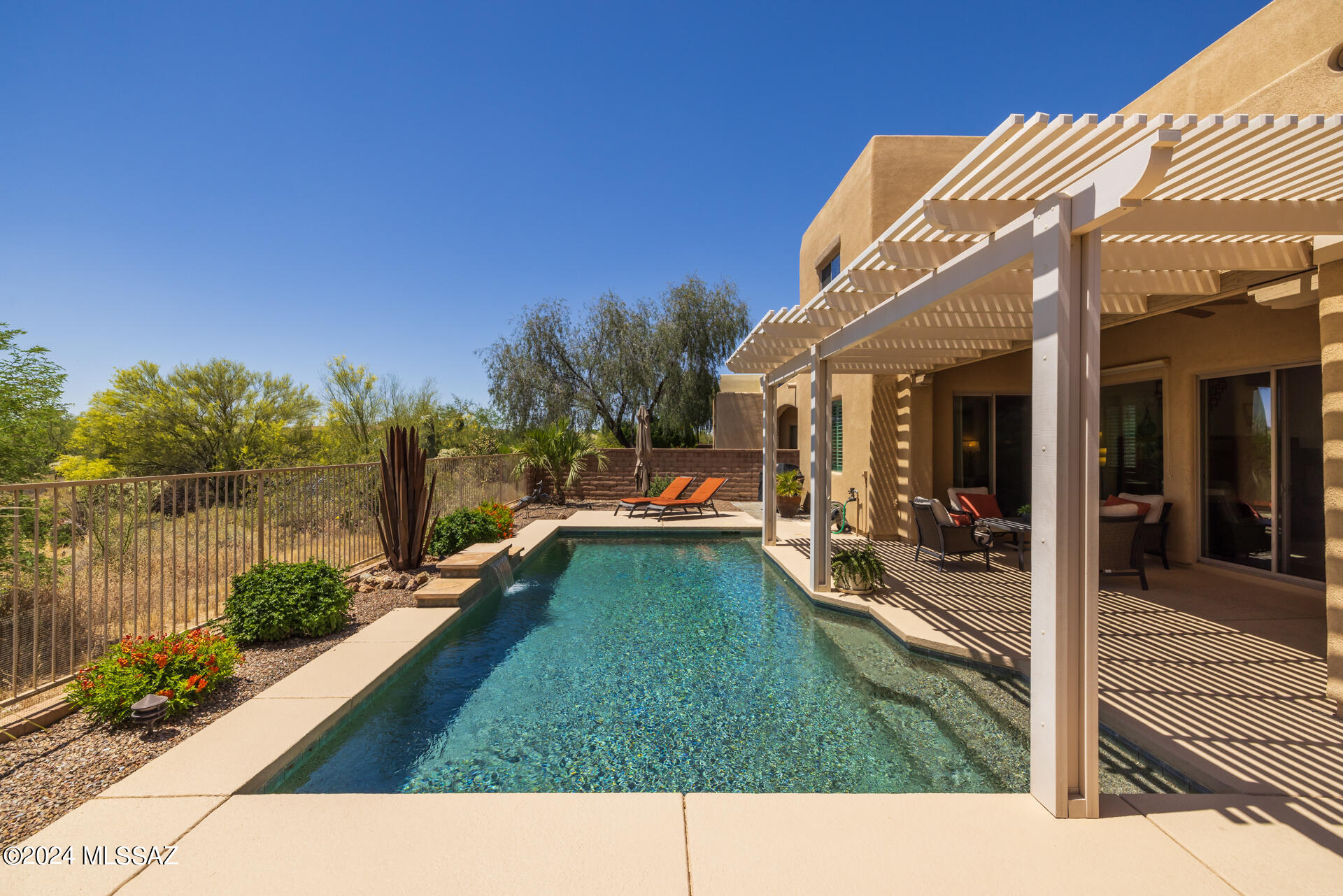 Welcome to this gorgeous home with a heated pool located behind the gates of  Skyranch! Boasting a charming front courtyard, 4 bedrooms, 3.5 bathrooms, an upstairs loft, and beautiful upgrades throughout this home is easy to fall in love with. The formal dining room offers a stunning chandelier and direct access to the kitchen where you will find beautiful cabinetry, premium slate gas appliances, granite countertops, and a peninsula breakfast bar. The great room is cozy with a corner fireplace, dramatic tall ceilings, and plenty of natural light. Through the sliding glass door, you will find a backyard oasis with a stunning view of a Sonoran desert common area. Enjoy the covered patio complete with a ceiling fan and an added pergola extension that leads to a serene gas-heated pool with a waterfall feature. Back inside you will find a downstairs primary suite with private access to the backyard, and a spa-like ensuite featuring a dual sink vanity, a soaking tub and separate tiled shower, and an expansive walk-in closet. Upstairs is a loft, 2 bathrooms, and the remaining bedrooms. Bedroom 2 is oversized and complete with a ceiling fan and shutters. Bedrooms 3 and 4 share a Jack-and-Jill bathroom and are move-in ready!  Additional features include laundry room cabinets, a water softener, security cameras,  and an oversized garage with a water faucet plumbed with cold and hot water. This spotless well-maintained home is a must-see!

Nestled in the scenic landscape of Marana, Arizona, Skyranch offers an outdoor enthusiast's paradise with easy access to a multitude of hiking trails, including the picturesque Wild Burro Trailhead, Upper Javelina Trailhead, Tortolita Preserve, and Dove Mountain. Embrace an active lifestyle surrounded by nature's beauty, while also enjoying proximity to renowned golf courses, making it an ideal haven for both adventure seekers and golf enthusiasts alike.