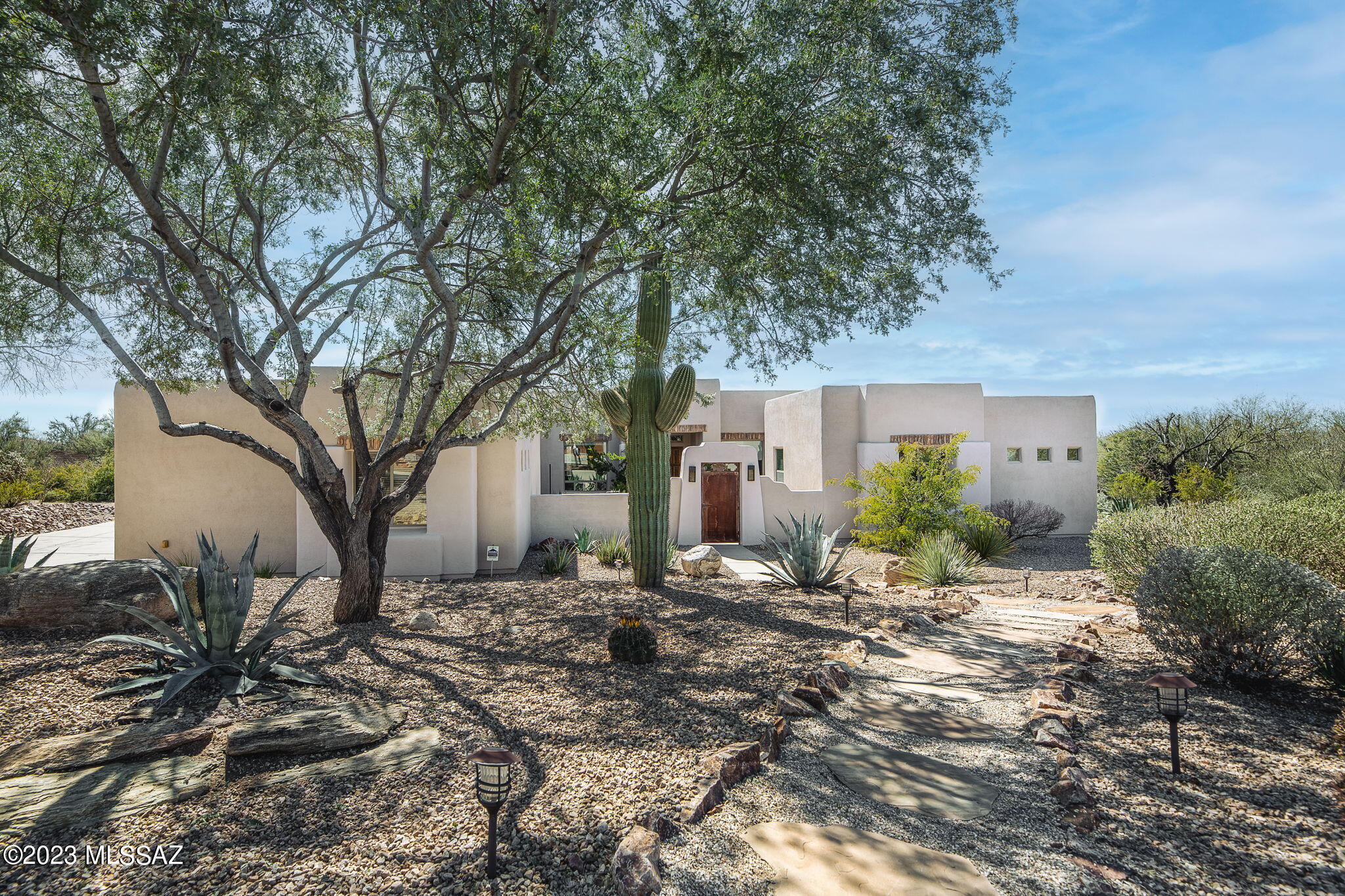 This Beautiful 4,334 SqFt, 4 BD, 4.5 BA Southwest Contemporary style home is located in the sought after gated community, Dos Lagos at Dove Mountain on a .77 acre lot, offering plenty of privacy, North facing Mountain Views, and Sensational Sunsets.  

You can't help but fall in love with this beauty from the moment you step through the large rustic gate into the private courtyard, appointed with mature plants and a spacious paver patio for enjoying the Mountain Views. The double door entry welcomes you into this well cared for open concept split bedroom plan. Located off of the foyer is a secluded Den with double doors and a Formal Dining Room. If you have a passion for cooking, you will absolutely love the kitchen featuring a breakfast bar, island with 5 burner gas cooktop, built-in oven and microwave, wine fridge, display cabinets, pullouts, and loads of counter space with 2 Built in desks, dining nook, and large pantry. The open concept plan is perfect for spending time with family or entertaining guests, as the kitchen is open to the expansive Great Room, offering rear patio access, a beehive fireplace, and a wall of windows overlooking the patio and pool. 

The South Wing of the home boasts a secluded spacious Owners Suite that is sure to satisfy, as it provides rear patio access and is appointed with 2 huge walk in closets, dual vanities, walk-in shower, and a soaking tub. 

Located off of the hallway is a large laundry room featuring a washer & dryer, utility sink, upper & lower cabinets w/countertop providing safe storage and work space. The laundry room also gives access to the attached 3 car garage, featuring built-in storage racks and a coated floor. Adjoining the laundry room is a large linen closet, and sizable bedroom with a walk-in closet, and en suite bath with single sink vanity and shower.  

The North Wing of the home is appointed with a Powder Room, sizable Game Room / Flex - Room, and two additional large bedrooms, both with en suite baths featuring a single sink vanity and wet room w/ tub & shower. 

To top it all off, when you aren't out enjoying the Active Lifestyle that Dove Mountain has to offer, you will absolutely love spending time outdoors at home, as the enclosed private backyard boasts a heated lagoon style pool w/ water feature, mature landscape, and an abundance of patio space that is perfectly suited for entertaining, soaking up some sun, enjoying the mountain view and spectacular sunsets.