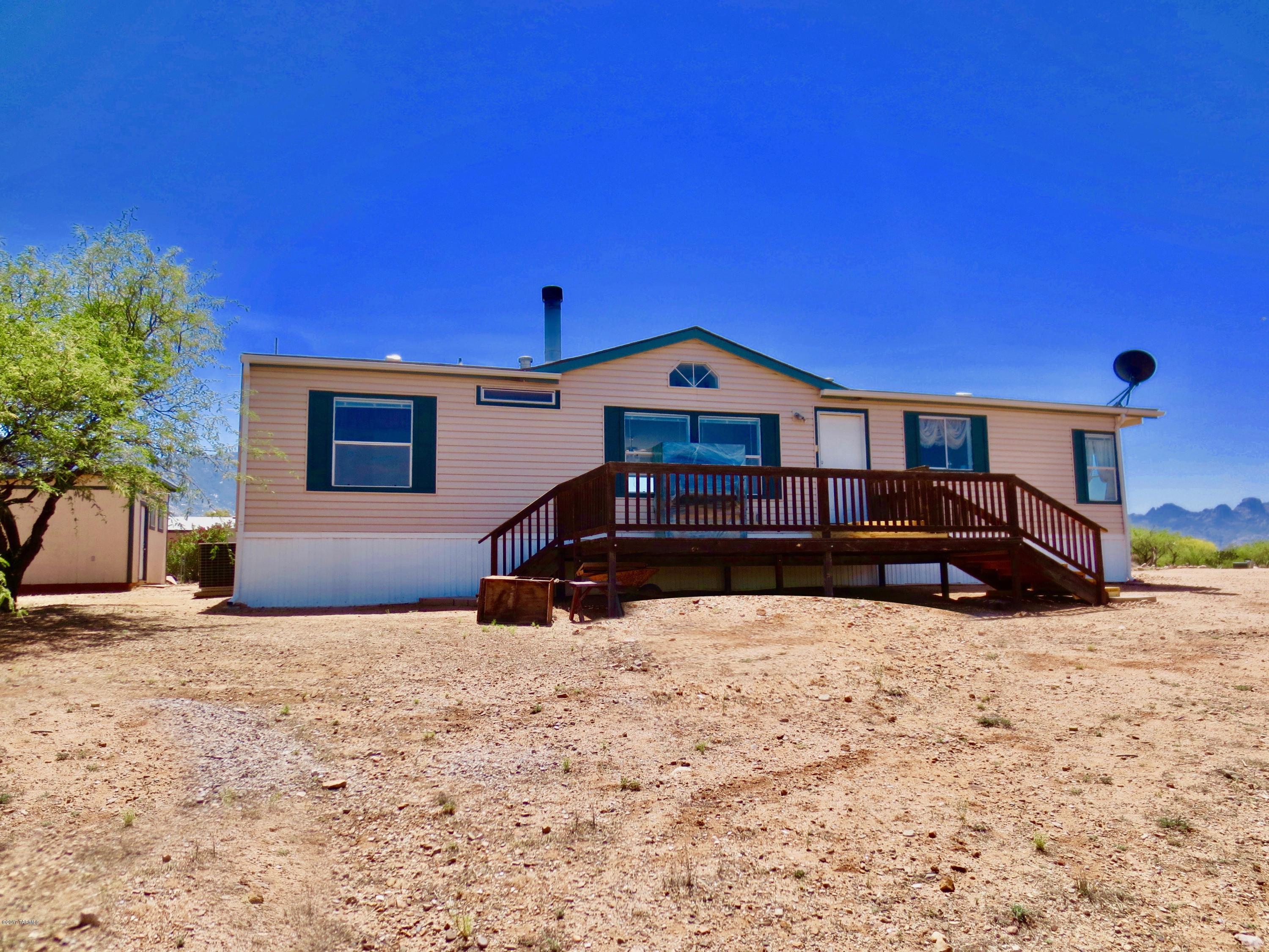 Seller will consider offers $189,900 to $199,900. BEAUTIFUL! MUST SEE! 3+ ACRE HILLTOP location w/panoramic views. Enjoy peaceful sunrises over the Catalina Mountains, magnificent sunsets across the valley & breathtaking star-gazing from rustic decking. Great neighbors. Rural ambiance. Zoned for horses/livestock. Access to schools, churches, healthcare, shopping, entmt. Open Kit w/bkfst bar, lrg dining area, water filtration, white appliances & plenty of counter/cabinet space. Split BR floor plan w/3 walk-in closets. Lrg Master Suite w/garden tub. Living Room w/gas fireplace. High ceilings; 3 ceiling fan/lights. Central AC. Enclosed laundry room. Shed w/great storage capacity. Perfect for RV parking. Second lot sub-dividable & equipped w/separate septic/utilities for snowbirds/rental.