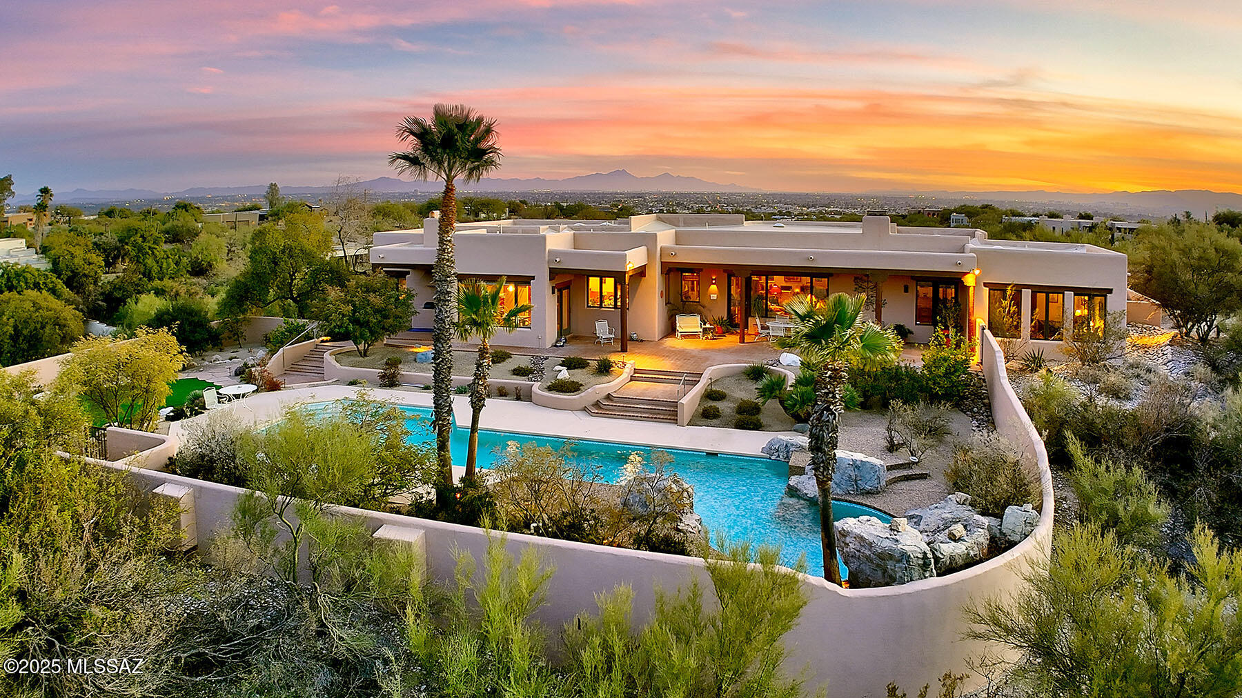 Exceptional Mike Wachs Southwestern-Style Home in Prestigious Catalina Foothills Estates #10.  Nestled within the sought-after, guard-gated Catalina Foothills Estates #10, this stunning 4,948 sq. ft. all-masonry stucco home sits on a rare double lot spanning 2.89 acres. Designed to embrace breathtaking, unobstructed views of the Catalina Mountain   and iconic Finger Rock, this five-bedroom plus den retreat offers the perfect blend of luxury, character, and timeless Southwestern charm.  Perched high on a hill, a circular driveway leads to an inviting courtyard entry, complete with a covered patio and captivating city views. A grand 4-inch-thick oak front door welcomes you into the spectacular great room, featuring Saltillo tile floors, viga-beamed and cedar strip ceilings with corbels an expansive display bookshelf, charming beehive fireplace, walls of windows, and a mud adobe bar area, all thoughtfully designed to maximize the striking mountain backdrop. An adjacent formal dining room provides a charming space for entertaining.  The warm and inviting Southwestern-style kitchen boasts a spacious center island, ample cabinetry, Talavera countertops, and a bright breakfast area. The gracious primary suite includes a cozy seating area, a beehive fireplace with a niche, a walk-in closet, dual vanities, and direct access to the backyard.  A generous 1,491 sq. ft. three-car garage with an RV bay provides abundant walk-in storage rooms. Outside, the park-like backyard is a true oasis, featuring an expansive rear porch, a lap pool with a waterfall, an artificial turf area, and stunning panoramic mountain views.  This quality-built home is a masterpiece of craftsmanship, brimming with charm and character at every turn. A must-see to fully appreciate!