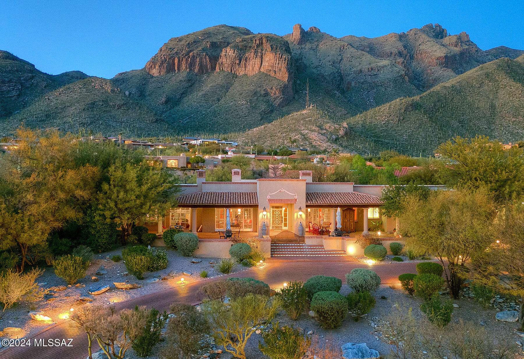 Welcome to this exquisite home, crafted by renowned La Quinta builders and designed by the esteemed Mike Franks, offering a perfect blend of old-world charm and modern conveniences. Situated to capture the breathtaking beauty of Tucson, with city lights greeting you from the front and Catalina Mountain views embracing you from the back, this residence promises a lifestyle of serenity & luxury. As you step onto the large welcoming patio and enter the home, you're enveloped by the warmth of the scored concrete flooring that flows seamlessly throughout. The open flow of the living, dining, and office space creates an expansive atmosphere, ideal for entertaining guests or simply enjoying quiet evenings at home. Step into a realm of culinary delight, where Dacor double ovens stand ready to turn your culinary aspirations into reality. Mosaic tile counters, meticulously crafted with precision, elevate the aesthetic charm while offering durability and ease of maintenance. Each detail, from the custom paint finishes to the carefully chosen fixtures, speaks to a commitment to excellence and luxury. Warm emanates from the flickering flames of the fireplace and a generous size island takes center stage, providing ample space for meal preparation, casual dining & lively conversations. The kitchen is also equipped with a Sub-Zero refrigerator, dedicated desk area and wet bar where you can mix up those speciality drinks. Walls of windows in the living areas frame the panoramic views, while wood plank ceilings with wood beams add a touch of rustic elegance. Additional highlights include a wine cellar, ensuite guest rooms, skylights, coved ceilings and wide hallways enhance the home's grandeur. French doors throughout open up to private patio spaces, inviting the outdoors in and providing seamless transitions between spaces. The spacious primary suite beckons with double closets, a cozy fireplace, and a luxurious bathroom featuring a large tub & separate shower. Step outside to discover the inviting backyard oasis, complete with a pool and lush landscaping, perfect for enjoying the sunny days and cool evenings Tucson has to offer. Featured in Tucson Lifestyle Magazine, this home is a true testament to refined living. With high ceilings, a circular drive, and plenty of parking, this residence offers both elegance and practicality.