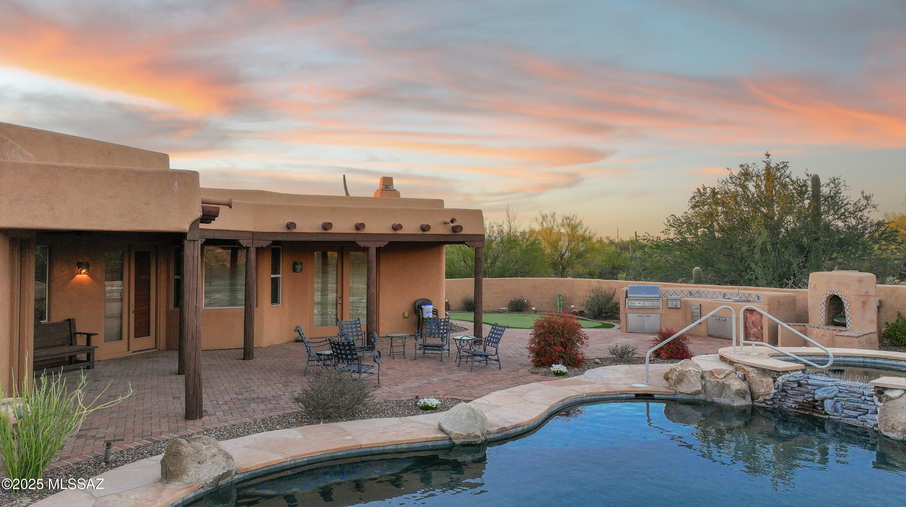Nestled in the prestigious Chaparral Heights community, this exquisite Southwestern-style home by TJ Bednar Homes offers privacy and breathtaking panoramic views on over an acre of land.  A brick paver driveway leads you to an inviting open floor plan, where timeless charm meets modern elegance.  Formal Living and Dining rooms showcase stunning wood-plank ceilings and beams, adding a touch of rustic sophistication.  The updated gourmet kitchen is a chef's dream, featuring knotty alder cabinets, GE Profile appliances, a 5-burner gas stove, a farm sink, a walk-in pantry, a breakfast bar, and a cozy breakfast nook.  Adjacent to the kitchen, the family room is highlighted by a charming gas beehive fireplace, while a versatile media/game room provides additional space for relaxation and entertainment.  Step outside into your serene east-facing backyard oasis.  Resort-like outdoor space includes a pebble-tec pool and spa with a waterfall, a custom-built outdoor kitchen, putting green, gas fireplace, and expansive flagstone and brick patiosall set against the stunning backdrop of Catalina Mountain views.  The primary suite is a luxurious retreat with a spa-like bathroom that includes a pebble-tile walk-in shower, soaking tub, dual sinks with granite counters, knotty alder cabinets, and a spacious walk-in closet.  Three additional guest bedrooms feature custom headboards, ensuring comfort and style for families and visitors alike.  Additional highlights: Solar screens for energy efficiency; Outdoor lighting to enhance ambiance; Roof recoated (2018); Exterior painted (2017); Energy-efficient 16 SEER HVAC system (installed 2019); Oversized 3-car garage for ample storage.  This home seamlessly blends timeless Southwestern charm with modern luxury and functionality.  Don't miss your chance to make it yours!