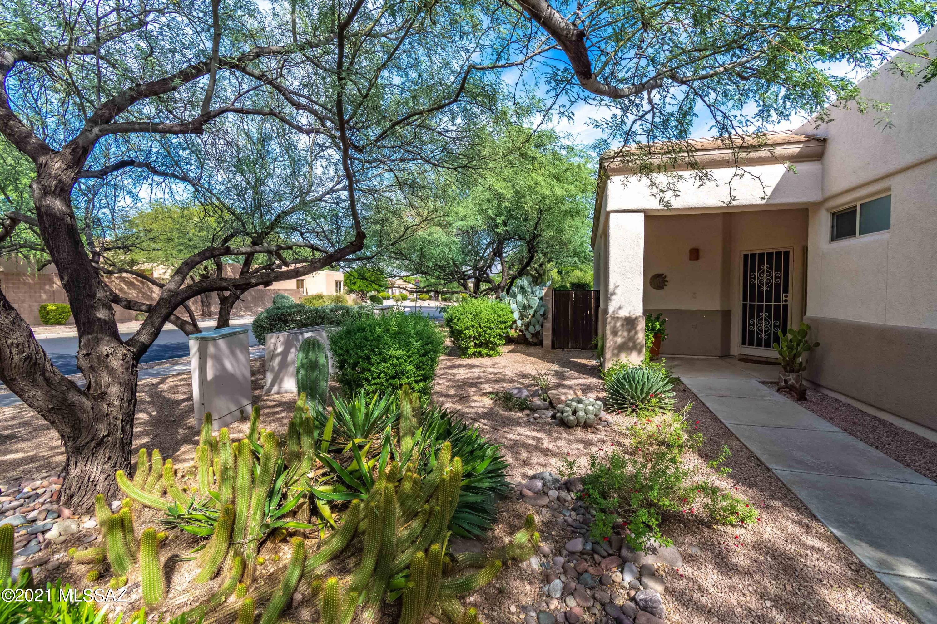 This one-owner home is on a coveted corner lot in gated Rancho Esperero and has been meticulouly cared for.  The home features a comfortable split floorplan with 3 bedrooms and 2 full baths. There are no interior steps, a welcoming entry and nice high ceilings with lots of natural light. The open floorplan is flexible with a generous great room and a second space off the kitchen that can function as a formal dining or a family room area.  The peaceful backyard has a covered patio, mature trees, and extended patio space with a wood burning fireplace, and creates the perfect zen-type outdoor living. Beautifully landscaped common area and three community pools areas round out this popular neighborhood.   Close to Udall Park, Sabino Canyon, shopping, and dining.
