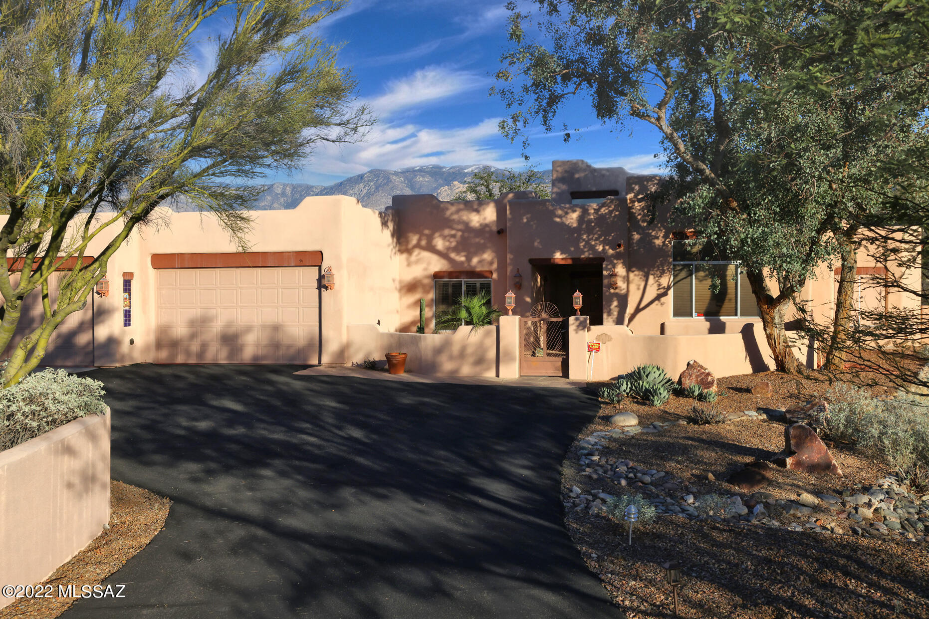 Awe-inspiring panoramic views are the highlight of this substantial Santa Fe nestled at the end of a long winding drive, seated on a private acre with unobstructed views of Pusch Ridge. This impressive 4 bedroom, 3 bath home features a spacious open floor plan with cathedral ceilings, stunning views of the Catalina mountains, romantic master suite with beehive fireplace and luxurious bathroom with large jacuzzi tub and walk-in shower. This sprawling home also features a sink or bar in-bedroom, an extra large formal dining room/friendly family room, 2 beehive fireplaces, and oversized skylights. Zone heating and cooling will make your comfort customizable. Corian counters and gorgeous ceramic tile provide an understated elegance. Large, 3 car garage features painted floors and abundant built-in storage.  French doors open to a private landscaped backyard and gorgeous flagstone patio with nearby waterfall feature. Whether enjoying a comfortable evening with the family or entertaining guests, this home has it all.