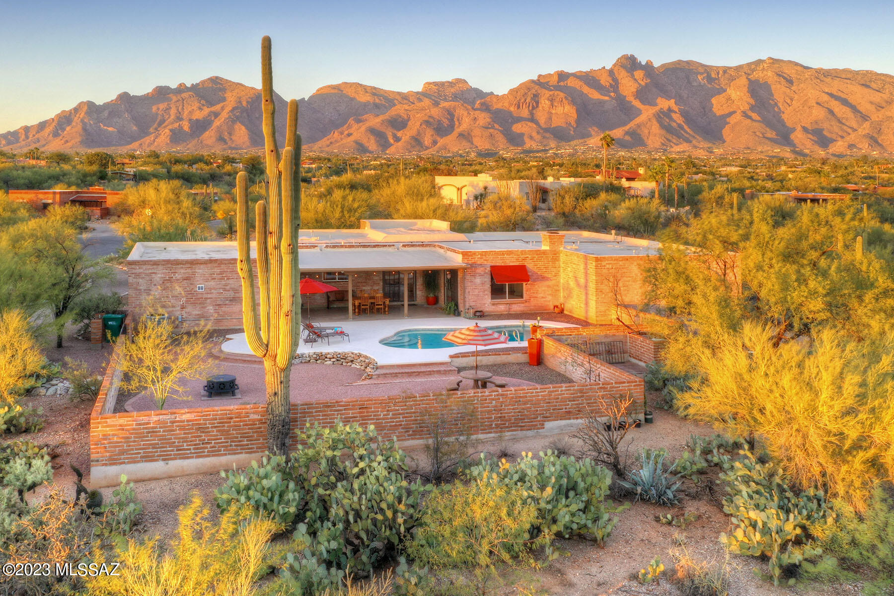 Nestled in the heart of Tucson's enchanting landscape, this magnificent burnt adobe home boasts timeless elegance, unparalleled vistas combined with modern comforts. Welcome to your dream desert adobe! Built by Ogonowski, this picturesque home beautifully blends into the natural desert surroundings, reflecting the rich architectural heritage of its time. It's a true embodiment of southwestern style. Sit down to inspiring Catalina Mountain views out your exquisite living room picture window, enjoy the ever-changing hues of the mountains against the desert sky. 10 ft high ceilings mixed with generous sized family, living & dining rooms are perfect for everyday living and hosting gatherings with family & friends. Primary suite boats dual vanities, ample walk in closet and private patio. With it's impeccable maintenance, this functional floor plan offers 4 bedroom & 3 baths. The open kitchen shines with stainless appliances, plenty of counter space including additional stainless counter top & walk in pantry. Your classic masonry fireplace in the family room will warm you on those cold Sonoran Desert nights. Relax, unwind and entertain under your covered patio, dive into your refreshing pool, and just try and count all of the saguaros from your front yard! Experience the best of desert living, your desert oasis awaits.