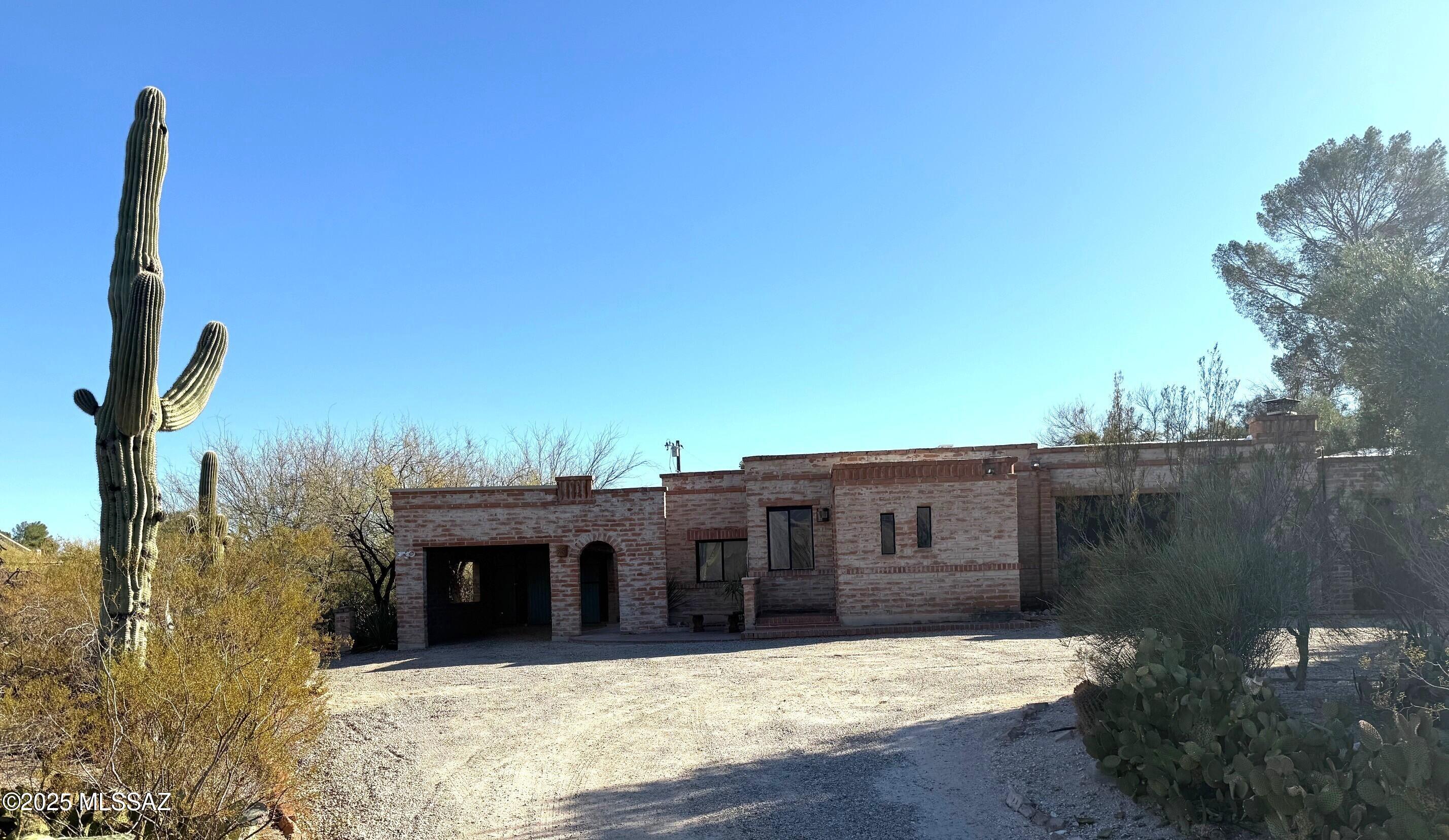 Stunning Burnt Adobe Home on nearly an acre  on Ft. Lowell Road adjacent to the Historic San Pedro Chapel. Lovingly renovated with Wood beam and plank ceilings, sparkling pool, Updated kitchen with Carrera marble counters, concrete and Mexican tile flooring, closet systems, wrought iron hardware, sconce lighting & 2 Fireplaces! Split bedroom plan, Master Suite with access to private pool.  Private Den or Library near entry, and AZ Room off Kitchen + 2 Bedrooms and Hall Bath on East side. Zoned Central AC & Split System Cooling & Central Gas Heat. Set back from the road behind a gated entry with Mature Desert Vegetation for privacy and dedicated conservation easement along north side of property to preserve privacy. Nearby Ft. Lowell Park & EZ access to TMC!