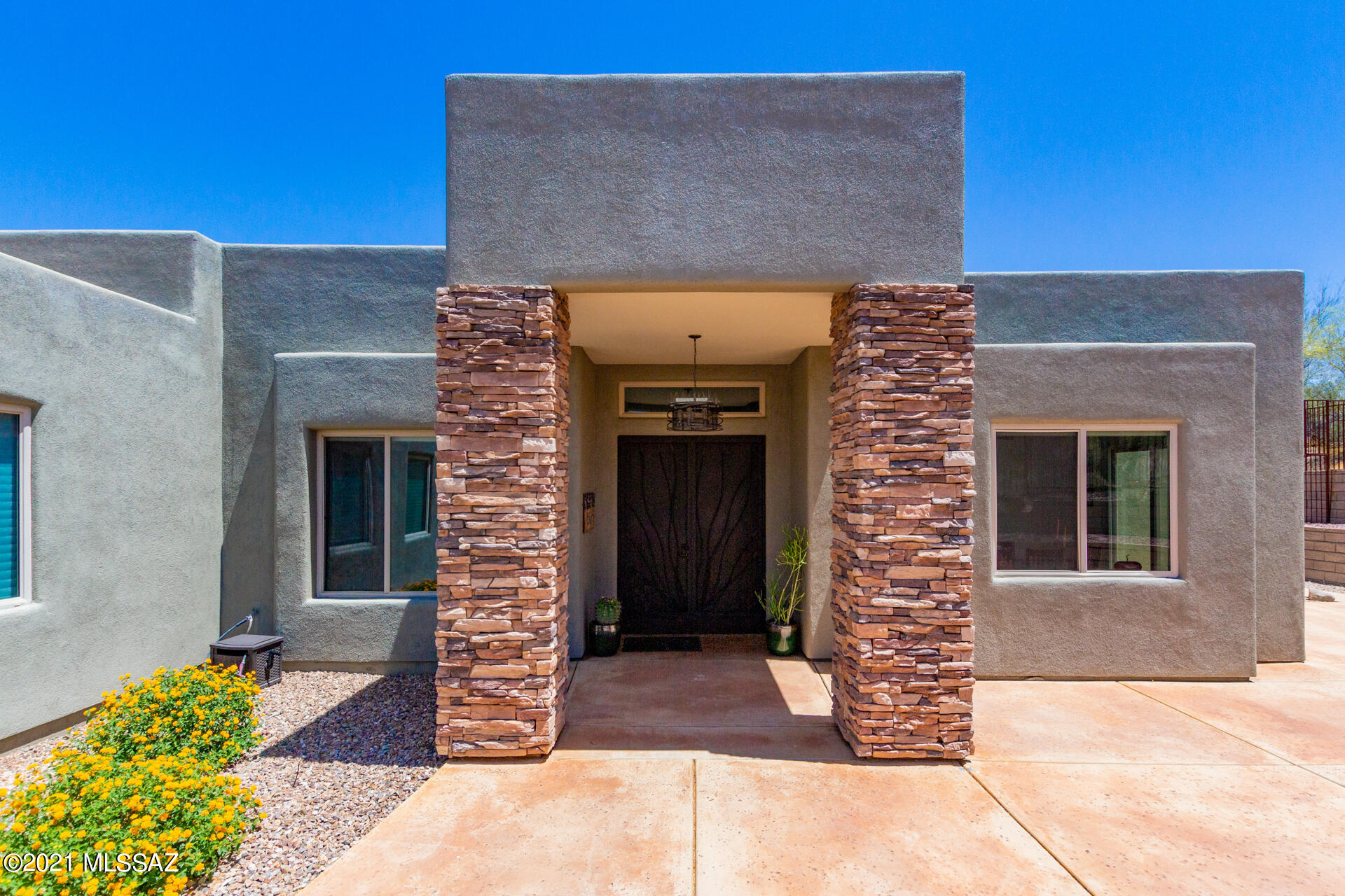 This gorgeous home nestled on 3.32 acres is perfect for entertaining and will not disappoint the most impeccable buyer. Upon entering, appreciate the open concept and welcoming space complemented with grand windows to view the rolling hills, mountains, and natural desert. The chef's kitchen offers side by side Jenn-Air refrigerators, Thermador gas oven, dual ovens, dishwasher, and large center island with stainless steel sink. Cozy up to the gas fireplace which is enhanced with stacked stones from floor to ceiling.  The generous Master Suite has an oversized walk-in closet with built-in shelving and connects to the ensuite bath with his and her sinks, step in shower, and separate tub with breathtaking views. All three guest bedrooms have a slider to the exterior. There is a jack-n-jill bathroom, another full bath and powder room bath. The overall finishes speak luxury with Italian tile, maple cabinetry, and granite counter tops throughout the home.  Step onto the patio with ceiling fans and take in the spectacular desert views. The Pebble Tec pooland swim up bar are complimented with an outdoor kitchen, grill, and pizza oven. The three car extra deep garage with work bench, extra storage area, and epoxy floor will appeal to any car enthusiast.  The owners have viewed several wildlife species in the natural landscape yard, and they have hot air balloon sightings annually! This desert sanctuary is situated in the prestigious gated Tucson Mountain Reserve.