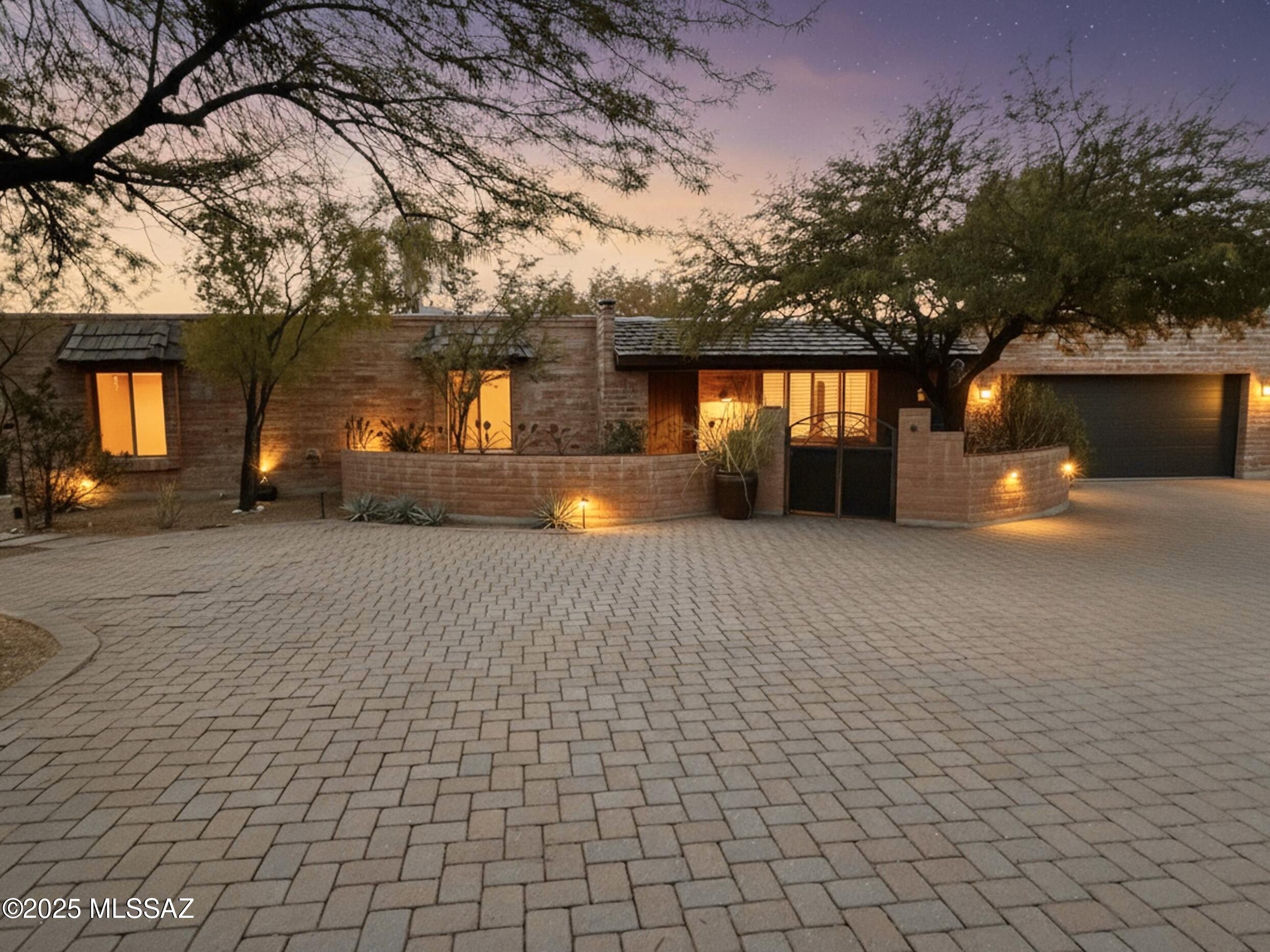 Motivated Seller! Highly sought-after Foothills living home with beautiful mtn and city views. A paved driveway leading to a charming gates& fountain. Doors open to a spacious family room featuring  beamed ceilings, with adjoining formal living and dining areas. A dramatic fireplace leads to a wall of windows that draws you toward the stunning backyard retreat complete with sparkling city lights, a kiva fireplace, built-in bancos multiple patios, lush landscaping, and meandering paths. The kitchen is the heart of the home, offering granite counters, two sinks, and generous storage. Two primary suites include walk-in closets w/ direct access to the bckyd. A den with built-ins and an huge laundry/bonus room add even more versatility with a spacious home. Schedule a showing today!