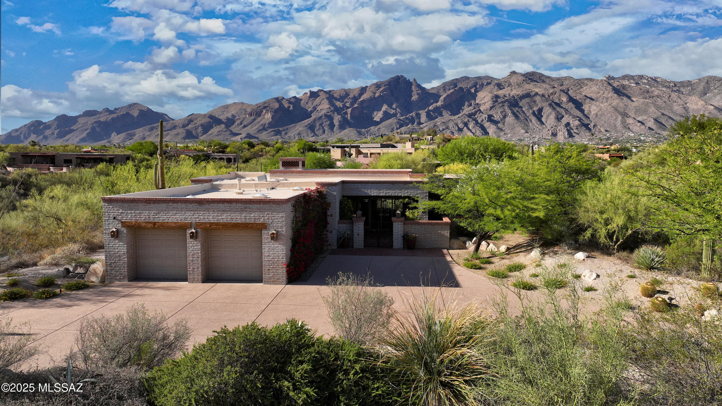 Not for individual sale, will only be sold as part of a 4-lot sale including 4885 N Via De La Granja, 4915 N Via De la Granja, 4855 N Via De La Granja, and 3801 E Sumo Quinto. Welcome to a truly extraordinary opportunity in prestigious Catalina Foothills - a unique offering of four combined lots spanning over 7.3 acres of serene desert landscape with two luxury homes created by Michael Franks, and two vacant parcels preserved to protect the stunning views. This is your chance to own a private estate that embodies the essence of Southwest elegance, privacy, and versatility.
Step into the main residence (built in 1992, 4,473 sq ft) through a charming brick courtyard with fountain, an enchanting prelude to the beauty that lies within. As you enter, your gaze will be drawn to dramatic wooden ceilings with vega beams, a hallmark of true Southwestern craftsmanship. The expansive great room boasts breathtaking views of the distant mountains and sparkling city lights, all enjoyed from the warmth of a spacious and grand place to spend time with your guests and loved ones in front of the statement stone fireplace. This room could easily be considered the heart of the home.
The kitchen is rich in charm and offers excellent flow, ideal for the home chef to customize and enhance. The primary suite is a private retreat with oversized rustic wooden doors, its own fireplace, and inspirational views. The en suite bathroom features unique character throughout, from its spacious walk-in closet, dual vanities, soaking tub, and walk-in shower, providing the perfect mix of function and relaxation.
Don't miss the office, with a north-facing picture window framing mountain views.  Split on the other end of the home are two additional en-suite guest bedrooms.
The back patio is the crown jewel of the main home and a captivating space designed for unwinding and soaking in the uninterrupted panoramic views that make Tucson's Catalina Foothills so sought after. It's no wonder the current owner chose to purchase and preserve the two adjoining vacant lots, ensuring peace, privacy, and unobstructed vistas for years to come.
The guest house (built in 2017, 2,250 sq ft) is a stunning standalone residence featuring high-end Southwestern style with a modern twist. Allow yourself to be captivated by the saltillo tile floors, vega beam ceilings, and show-stopping modern kitchen with an oversized copper island and high-end stainless steel appliances. Whether used for generational living, a private retreat, rental income, or guests, this home delivers luxury and necessary flexibility.
This rare compound is more than just a property, it's an investment in lifestyle, beauty, and long-term value. Properties like this seldom come to market, especially in such a desirable and prestigious community.  Schedule your private tour today and experience firsthand what makes this one-of-a-kind Catalina Foothills estate so exceptional. Don't miss your chance to own a piece of Tucson luxury that truly stands apart.