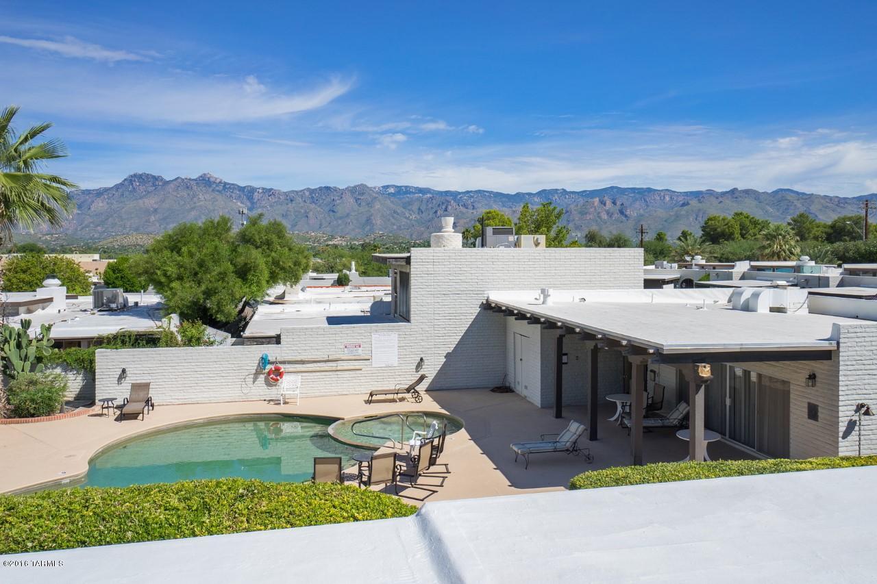 Impressive Townhouse in Convenient Northeast location, close to Restaurants, Shops, Bus Lines and Udall Park. Panoramic Mountain Views from Rooftop Sky Deck overlooking Community Pool and Club House.   Stunning Front Elevation, Deep Setback, Spacious Driveway and Private Courtyard Entry.  Contemporary Floor Plan and a Clean, Fresh Interior.  Big Windows and Glass Sliders for that Indoor-Outdoor Connection we Love!  Upstairs Master Suite with Balcony; Guest Bedroom & Bathroom on Main Level.  Cool, Modern, Lovingly Maintained and Move-in Ready.