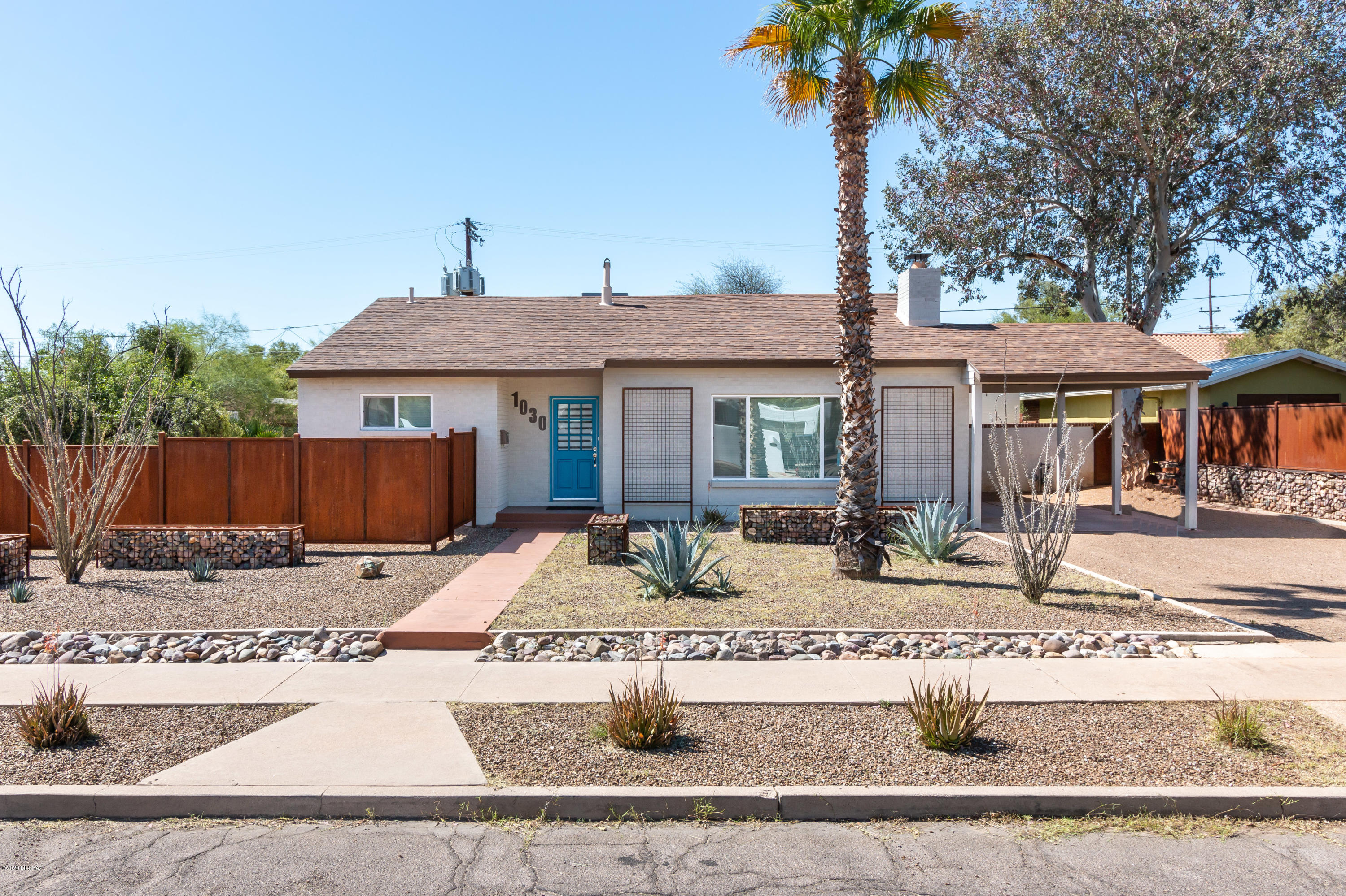 This gorgeous home in Jefferson Park is nestled on a huge lot with a charming 579 SF guest house. The 2 bed, 1 bath main house is nicely updated with ceramic wood tile throughout and carpets in bedrooms. The spacious living room ceiling boasts beautiful exposed beams, a cozy fireplace, and built-in shelving. The hall bath includes a lovely dual vanity with granite counters and a tile-surround shower. In the kitchen you'll find it all – granite counters, gas range, stainless appliances, and soft close drawers. The studio guest house is complete with the same stylish upgrades – exposed beams, ceramic wood tile throughout, granite counters and stainless appliances in the kitchen, a ¾ bath with tile-surround shower, and an extra room with W/D hookups. The huge backyard is blank slate and perfect for an entertainer! Located close to UA, Banner UMC, shopping and restaurants, this home has it all!