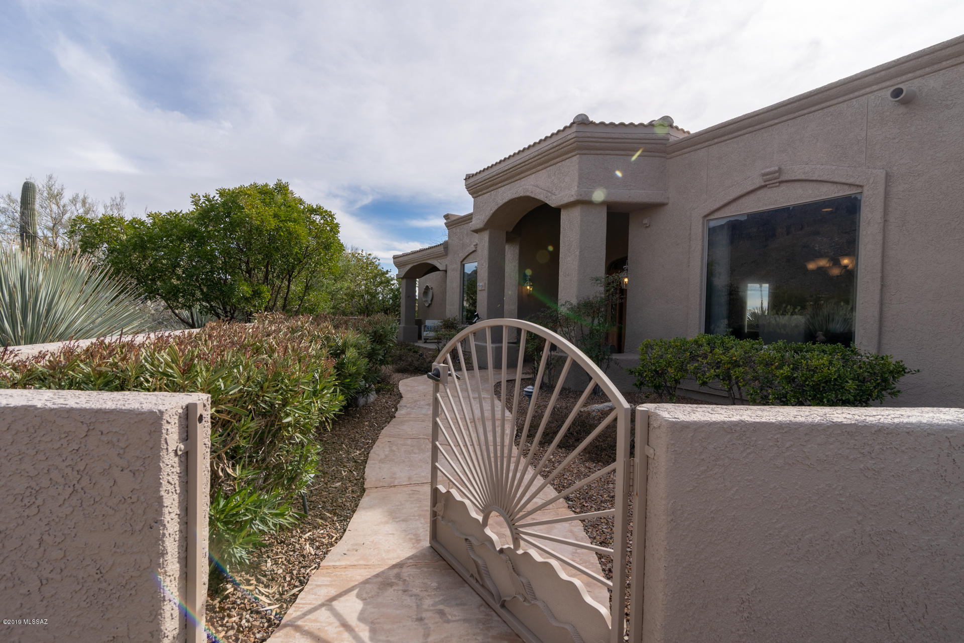 Large one level SW Contemporary in prestigious guard gated Pima Canyon Estates on private 1 acre corner lot. Mountain and city views with bonus tandem garage space & large driveway for guest parking. Open floor plan  on one level, not even a step up from garage. Large Master suite and convenient home office with mountain view. Large covered entertaining patio with city view. Close to shopping, schools, restaurants and the Pima Canyon hiking trail.