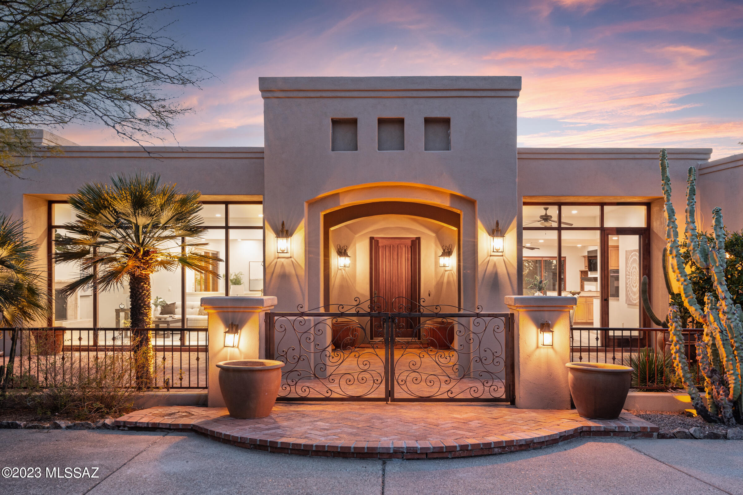 Located in exclusive, guard-gated Catalina Foothills Estates #10 in the heart of the foothills, this one-level Michael Franks, masonry-constructed luxury desert residence on a 1.6-acre homesite delivers true privacy, views, & an exceptional architectural presence. A long driveway leads you to a sizable, exposed aggregate motor court & the front courtyard w/ a custom iron gate, an impressive portico entry, & a red brick patio area. A dramatic entry w/ a soaring wood-beamed ceiling is centered between the formal living/dining area & the kitchen/family area. This open space, complimented by walls of wood-framed windows, flows effortlessly between the casual & formal spaces w/ direct access to the wraparound covered patio & backyard, merging the indoor and outdoor spaces.CONTINUED The formal living room with fireplace is adjacent to the spacious formal dining area, and the temperature controlled 2000+ bottle wine room. The kitchen, with custom cabinets and granite countertops, has a center island with a breakfast bar and a big walk-in pantry. An informal dining area/breakfast nook opens to the cozy family room with a fireplace and custom built-ins. Truly impressive; spacious primary suite with fireplace has views and privacy.  The huge primary bath with a dual sink vanity, separate shower, and soaking tub has an oversized closet with built-ins. French door leads to backyard pool and spa. The private, secluded resort-style backyard with pool and spa is surrounded by the beauty of the desert and showcases the remarkable Tucson sunsets. The nearly 1100 square feet of deep, covered patio with wood ceilings wraps around the back of the home, providing outdoor living and dining space.  Desirable north/south orientation.  Oversized 3-car garage is 1116 square feet and has built-in storage cabinets and an additional storage closet. This prime foothills location is convenient to the best golf courses, country clubs, restaurants, shopping, the University of Arizona, and downtown. Quickly access the Rillito River Path and access the Loop, a 133-mile connected bike path that spans the city. Highly rated District #16 schools.
