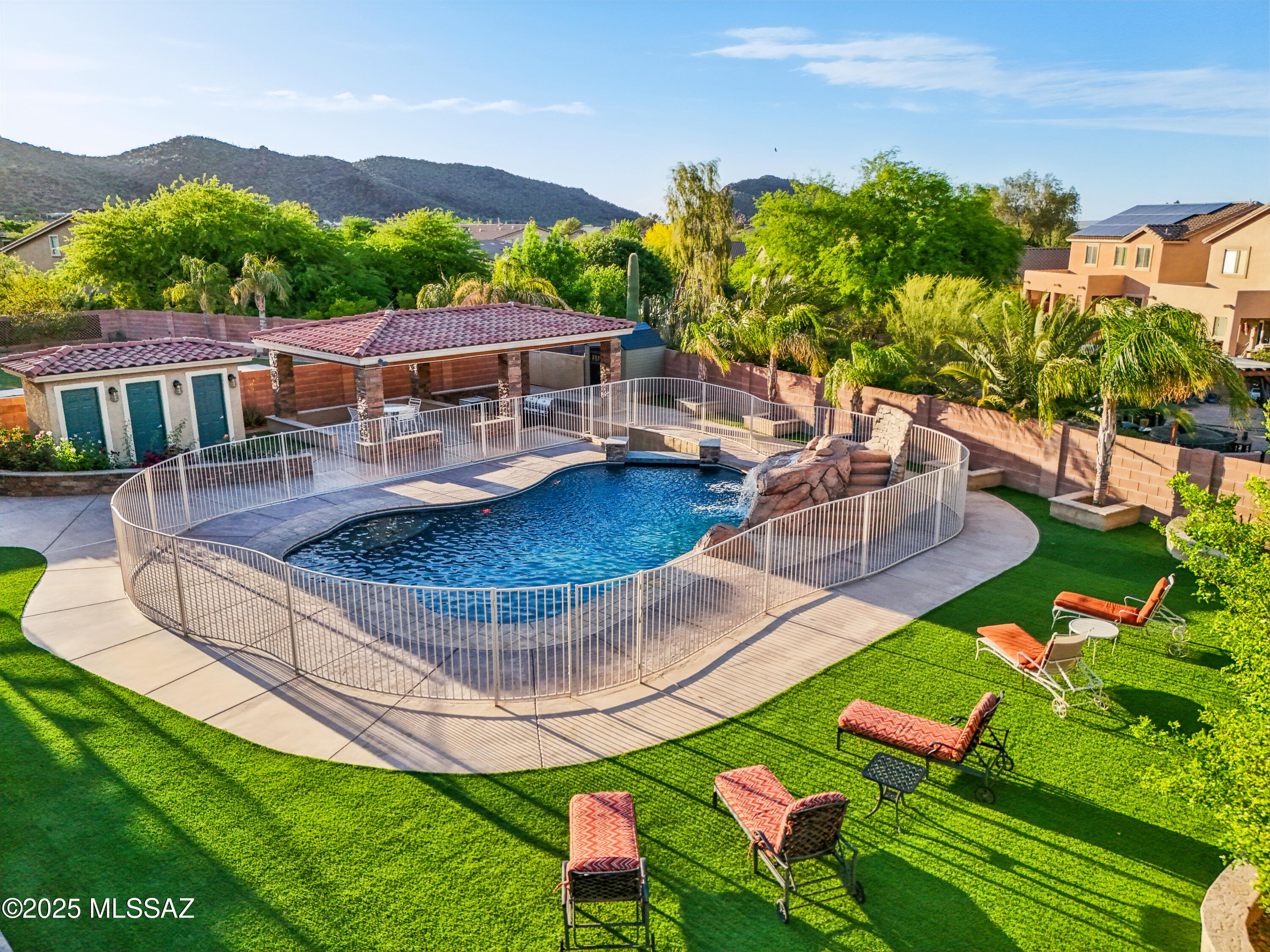 Escape to your own private resort in this stunning residence, meticulously designed for luxurious living and unforgettable entertaining. The backyard is a showstopper, featuring a breathtaking pool complete with a cascading waterfall, ambient evening lighting, and a swim-up pool bar. Steps away, the incredible in-ground outdoor kitchen offers seamless service to the bar, perfect for hosting gatherings. Guests will appreciate the convenience of the dedicated outdoor restroom and shower. Lush, low-maintenance turf and mature fruit trees complete this private paradise.
Step inside to discover unparalleled comfort and style. This exceptional home boasts three distinct master suites, offering privacy and luxury for family and guests alike. Movie nights reach a new level in the dedicated home theater - fully equipped and included with TV, plush furniture, and all accessories. Maintain your fitness routine in the convenient home gym space with access from inside or outside of the house. Enjoy breakfast at the balcony with beautiful mountain views and an unparallel view of your backyard!
No detail has been overlooked, with upgrades including sophisticated designer brand lighting fixtures throughout, a whole-house water softener system, and energy-saving solar panels. This is more than a home; it's a turn-key lifestyle destination. Don't miss the opportunity to own this exceptional property. Schedule your private showing today!