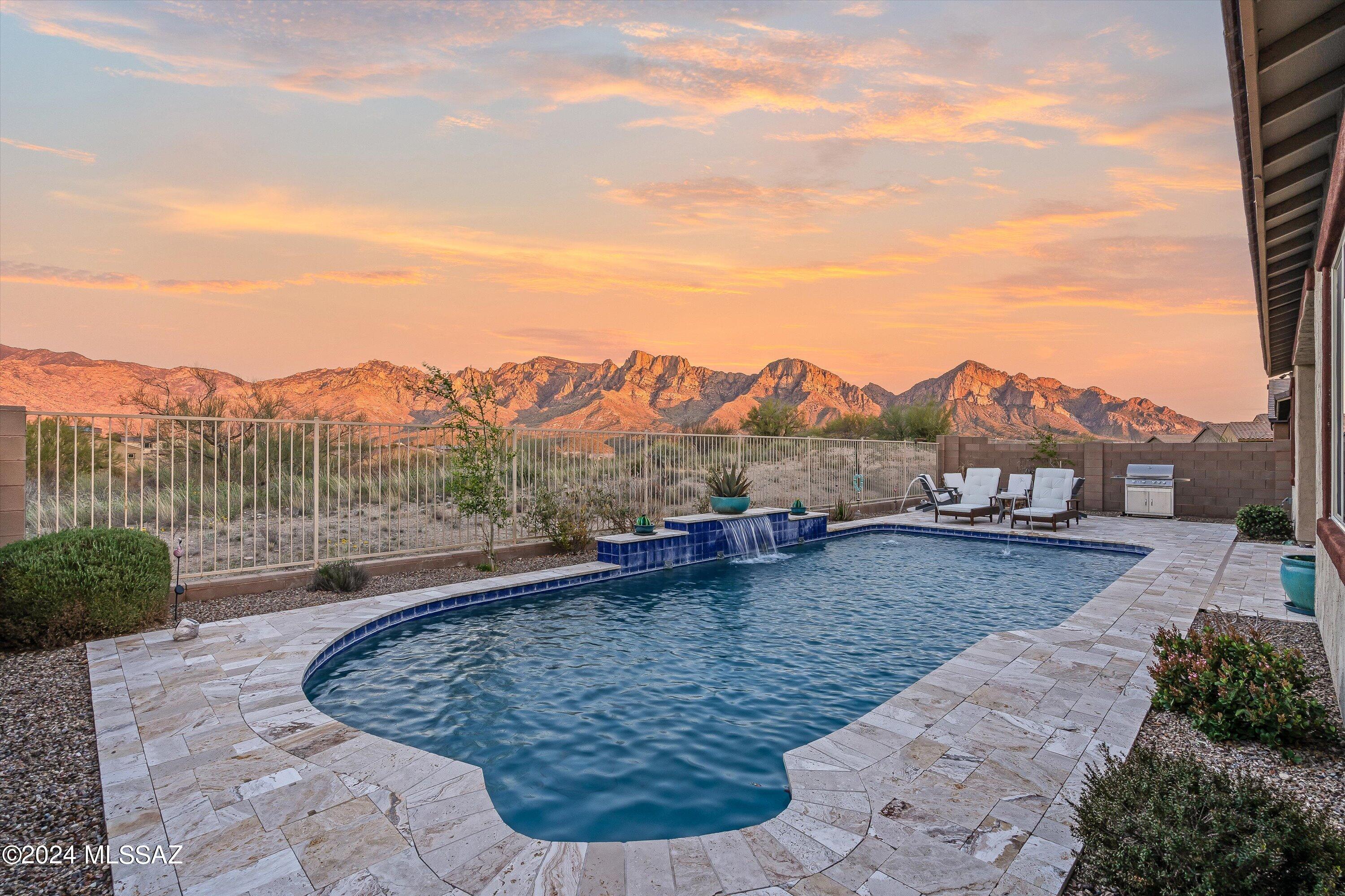 Absolutely stunning 5BD/3BA home with pool & breathtaking mountain views in the Villages of Silverhawke community. The exceptional views of the Catalina Mountain, visible from anywhere in the backyard, will not disappoint. Whether in the pool or relaxing by the gas fire pit, the backyard is truly resort style living. Multi-Slide Patio Doors open to a covered patio that welcomes you to your incredible backyard.  The Chef's Kitchen offers Gas Stovetop, Large Island and Quartz countertops. Upgraded appliances and Lighting, roomy walk-in Pantry. The split floor plan home is perfect for entertaining with a separate area for a media room. Gated Community.