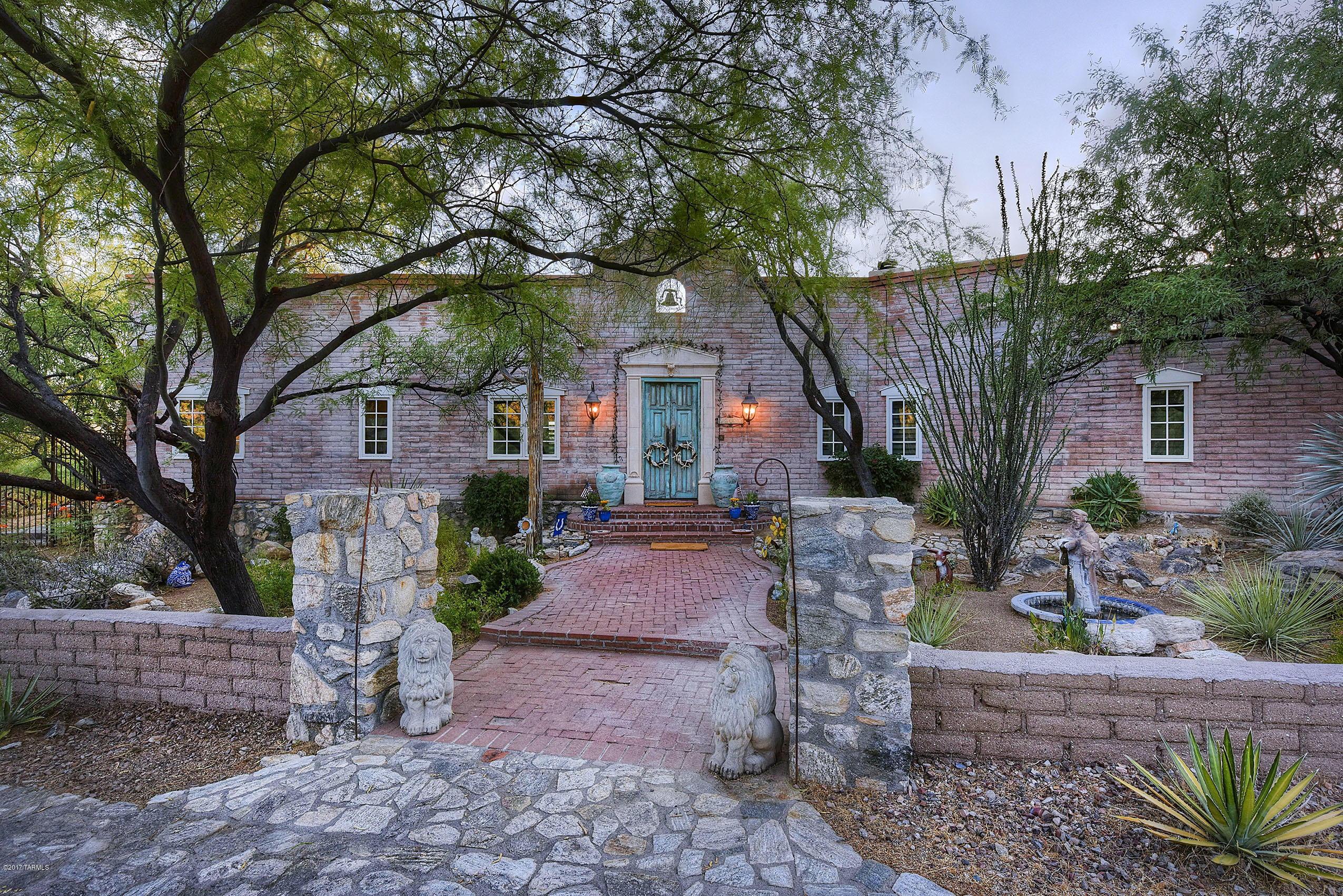 Custom home in the historic Joesler style design on 3.3 acres. An optional 3.3A available adjacent if desired.  This property is surrounded by over 80 saguaros, and at the base of Mount Lemmon with gorgeous city and mountain views for miles! As you enter the gated community, onto this property, you are greeted with 500 feet of custom rock driveway and transported into an oasis that makes you never want to leave your private retreat.
Amazing Gourmet kitchen with picture window view of the mountain features, top of the line GE Monogram appliances including 6 burner gas stove with griddle, and a separate bar area with additional full size dishwasher and 2 wine refrigerators.  Scored concrete throughout the home and styling details that impress at every turn which includes imported tile, custom built-ins, and french doors. Outdoor living space abounds with wraparound covered patio, beautiful fountain and a resort sized swimming pool and spa that overlooks the city.  This unique charming design is a must see!