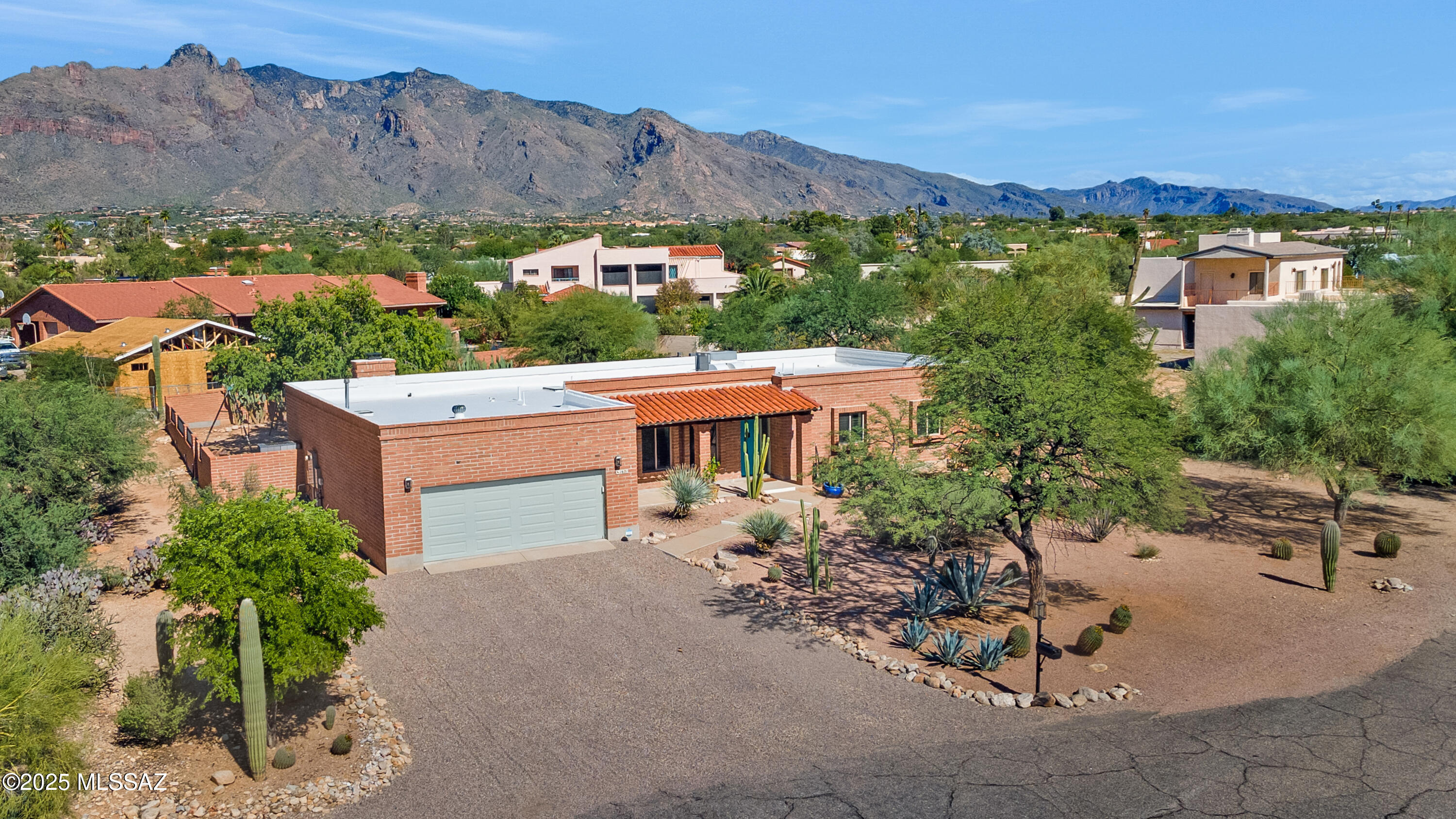 Price Reduced!! Truly special Burnt Adobe Southwestern Territorial home located in highly coveted Shadow Hills in the Catalina Foothills. Terrific mountain view, North facing rear yard on a cul-de-sac lot. Deeply loved, meticulously maintained, recently updated and upgraded kitchen, flooring and bathrooms. Modern cabinetry, counter tops and appliances enhance the chef's experience in the kitchen which is open to the family room with warm fireplace, making family dinners or entertaining more enjoyable. Entry foyer welcomes all to a versatile living room that could serve many purposes, the good-sized dining room is another flexible space to enjoy. The large primary suite leads to wonderfully upgraded primary bathroom which features a double vanity, plenty of storage, large walk-in shower and closet.
The resort style rear yard boasts a fabulous heated pool, separate grassy area, multiple play places and specimen plantings. Large covered patio, fire pit and mountain views add to the wonderful space. Roof and windows recently updated and adobe recently sealed.