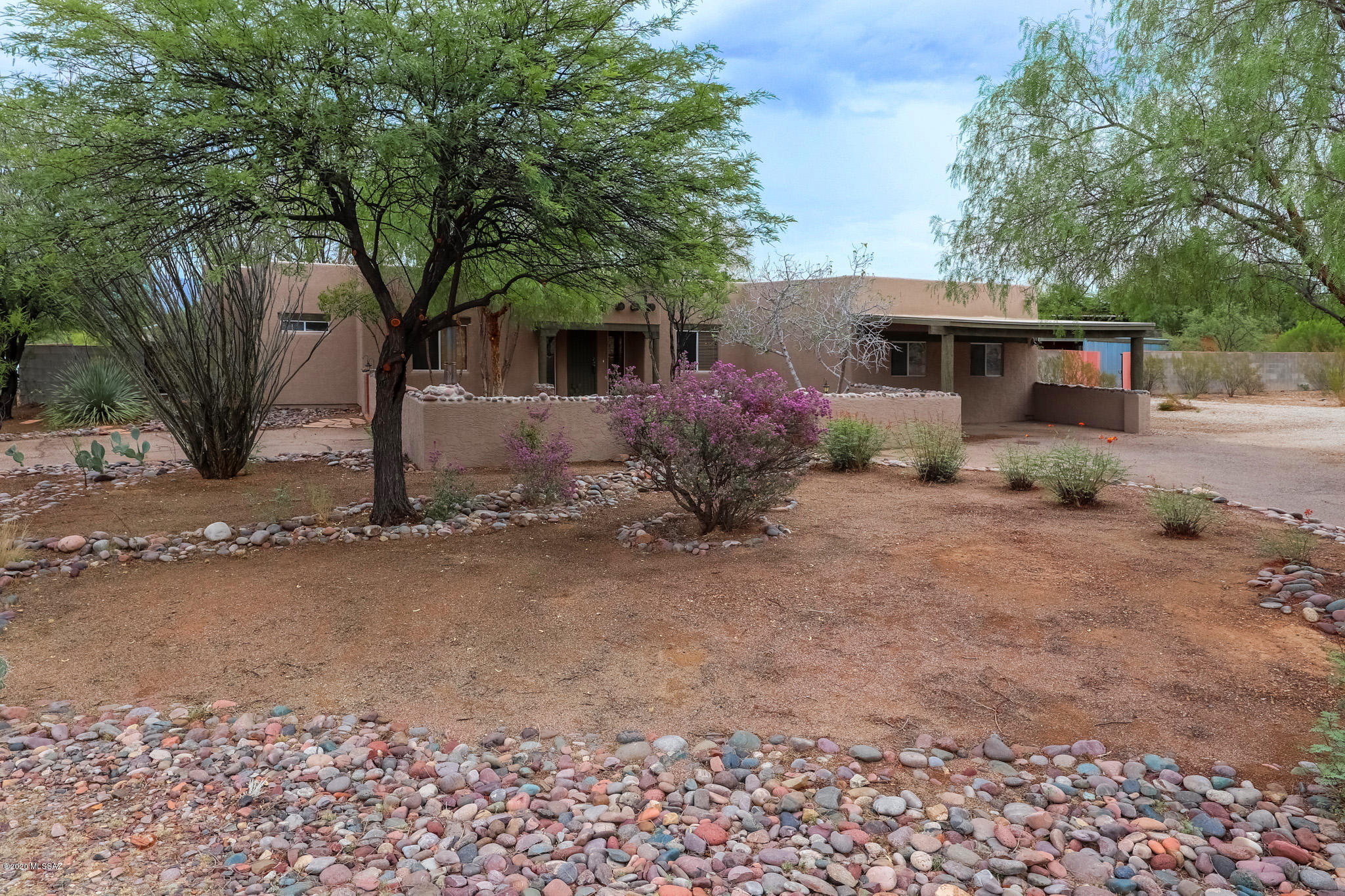 Fantastic piece of horse property w/ over an acre on paved streets in the Vail School District!!!  Enjoy the huge back yard with mountain views & full length covered patio, gazebo, pond, block planters and mature landscaping w/ large cottonwood trees.  This property is perfect for storing your RV and all your toys!  3 car steel carport, large side gate, 10'x 20' storage shed, & horseshoe driveway all on a flat usable lot.  Great curb appeal w/ mature landscaping and walled in court yard w/ fireplace. This large 4 bedroom, 2 bathroom split bedroom plan with a great room. The interior has been updated with new plank tile, remodeled bathrooms, new fixtures and fresh pain inside and out.  With acceptable offer the seller will convert the large game room back into over sized 2 car garage.