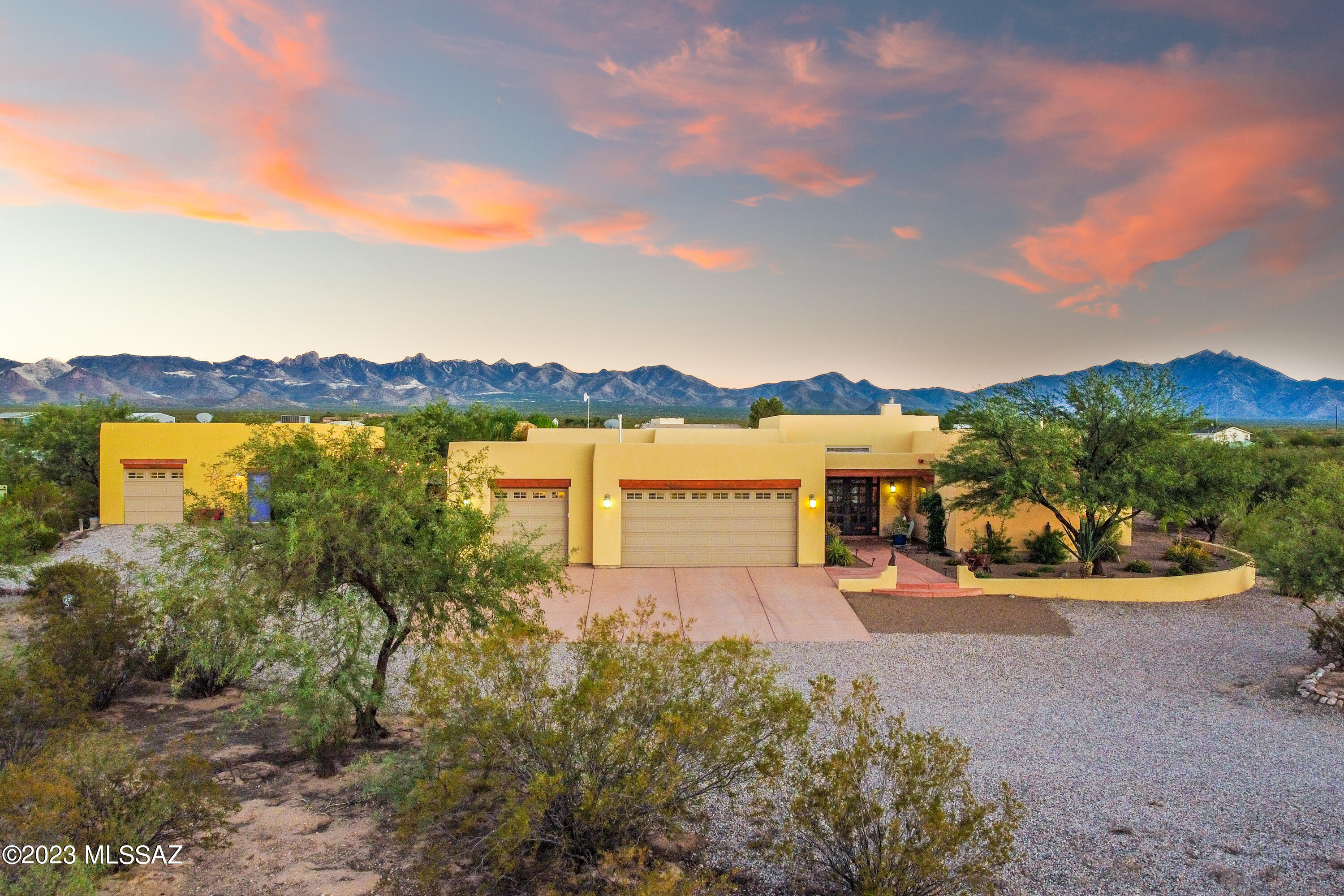 Discover the epitome of Southwestern luxury living in this custom-built Santa Fe style retreat nestled on over 5 acres of pristine desert landscape in Sahuarita, Arizona. This exceptional property offers a main residence and a guest house, seamlessly connected by a beautiful courtyard, blending authentic Santa Fe architecture with modern comfort and spaciousness.

The main residence exudes timeless charm with its classic Santa Fe style, featuring soaring ceilings and scored and stained concrete flooring, creating an inviting and warm atmosphere. Step into the generous living area that includes a welcoming great room with a rustic corner fireplace, perfect for cozy gatherings. The open-concept design seamlessly connects the dining area and kitchen, making entertaining a breeze. The gourmet kitchen is a masterpiece with custom cabinetry, prep area, granite countertops, and top-of-the-line stainless steel appliances, making it a culinary haven for any chef. The spacious primary suite boasts a tranquil oasis with an ensuite bath featuring a luxurious soaking tub, separate shower, dual vanities and a large walk-in closet, offering a perfect respite after a long day. Step outside to the expansive covered patio with captivating desert and mountain views. Enjoy alfresco dining, stargazing, and relaxation in the serene desert environment.

The guest house provides a separate sanctuary for visitors, extended family, or as a potential rental opportunity, offering a full kitchen, living area, bedroom, and bath and an attached one-car garage!

A stunning courtyard connects the main house and guest house, featuring a soothing water fountain, lush landscaping, and a built-in barbecue, creating an enchanting outdoor space for gatherings, relaxation, and culinary delights.

The property spans over 5 acres of pristine Sonoran desert, providing privacy, tranquility, and endless possibilities for outdoor activities. The desert landscape is thoughtfully landscaped with native plants, cacti, and majestic saguaros, creating a low-maintenance and picturesque environment. With ample land and space, the property could be developed into an equestrian haven with riding trails and facilities. Located in Sahuarita, Arizona, you'll enjoy the best of both worlds - the tranquility of rural living while still being in close proximity to the amenities, shopping, and cultural offerings of Tucson.

Come experience the ultimate retreat in the heart of the Sonoran desert. This property is a rare opportunity to own a custom-built home on a vast, private desert oasis, where the magic of Santa Fe meets the beauty of the Sonoran landscape. Schedule your private viewing today and make this enchanting property your new desert haven.